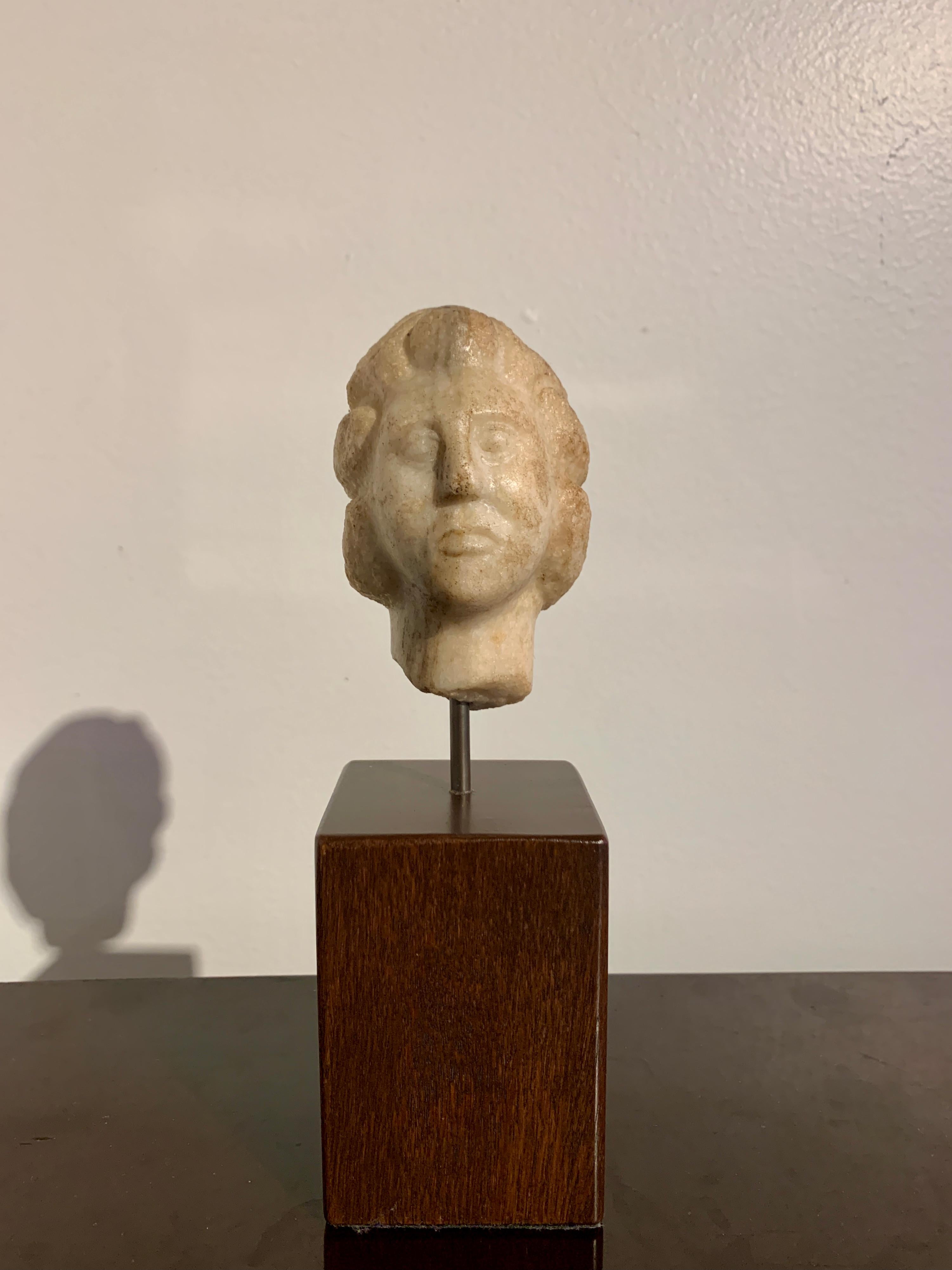A small carved marble head of a man, Parthian Empire, Hellenistic Period, circa 2nd to 1st century BC, modern day Iran. 

The small marble head carved in the Hellenistic fashion. The man stares out from wide eyes, a solemn and soulful expression