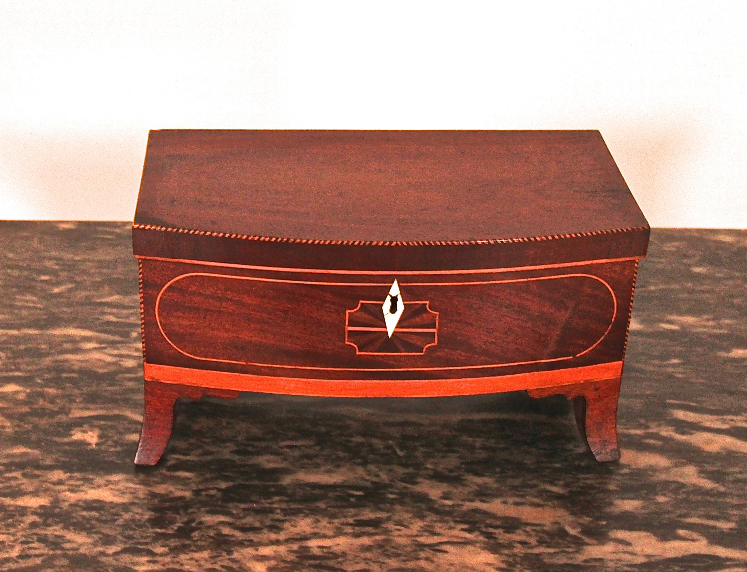 Small chest with lift lid. Inlay on lid and front. Bold French feet. New England.