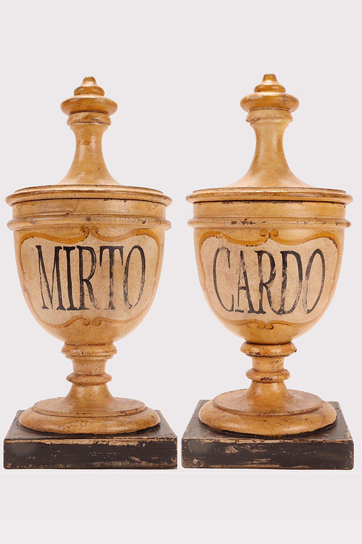 Set of two small wooden herbalist's apothecary vases (Thistle flowers, Myrtle berries) in the purest neoclassical style. The surface is finished with cream-white pastiglia with saffron-colored cartouche and gold-decorated trim, the names of the