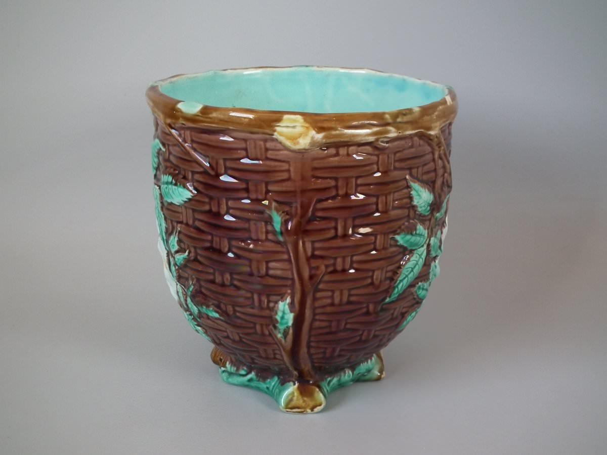 Holdcroft Majolica jardinière which features a basket weave exterior with dog rose blossom and leaves. Colouration: brown, green, turquoise, are predominant.