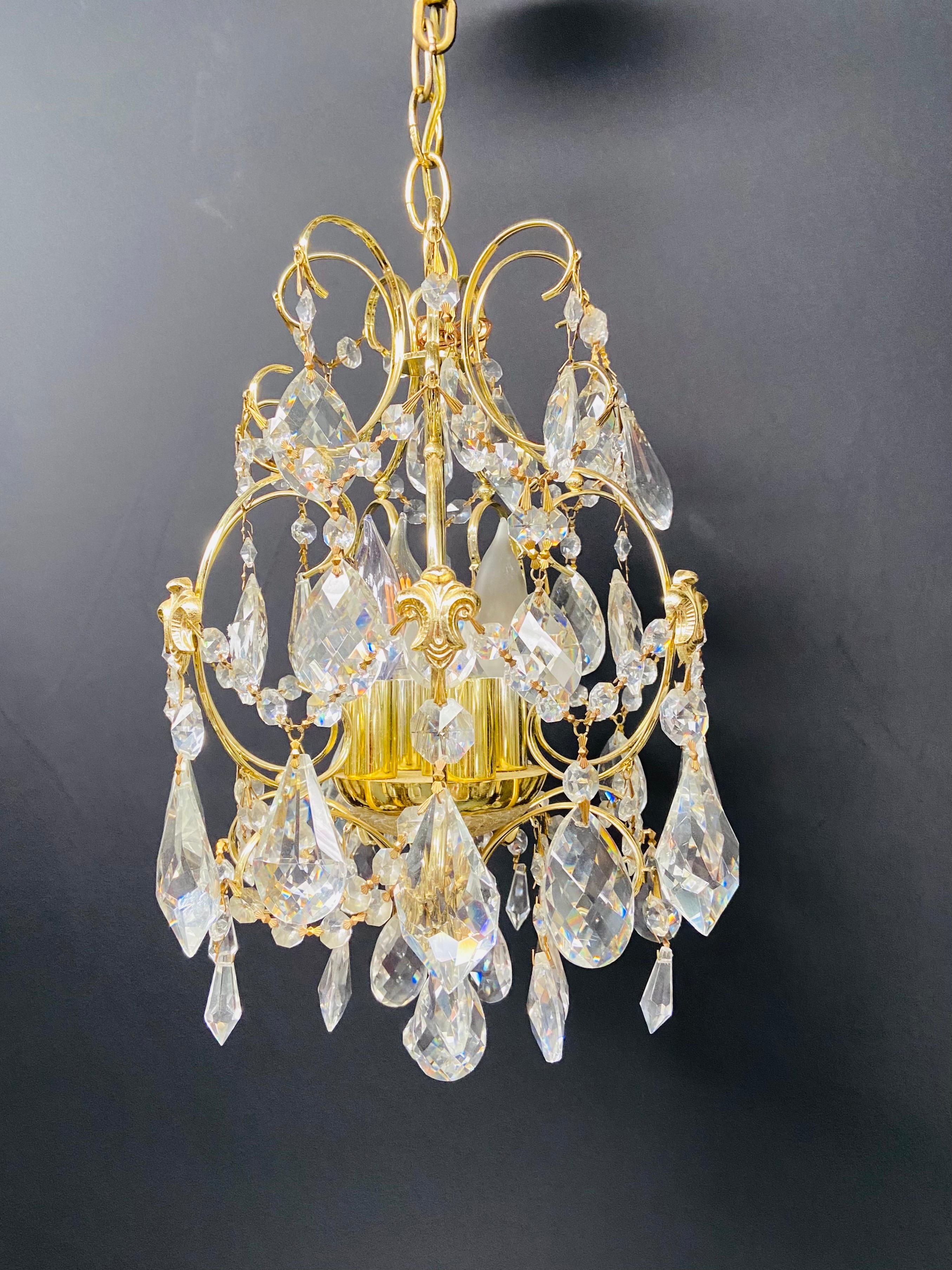 A beautiful cascading gilt brass frame and crystal chandelier in the Hollywood Regency style. The chandelier is in excellent condition and would look gorgeous in a foyer or a small living room.

Dimensions: 15