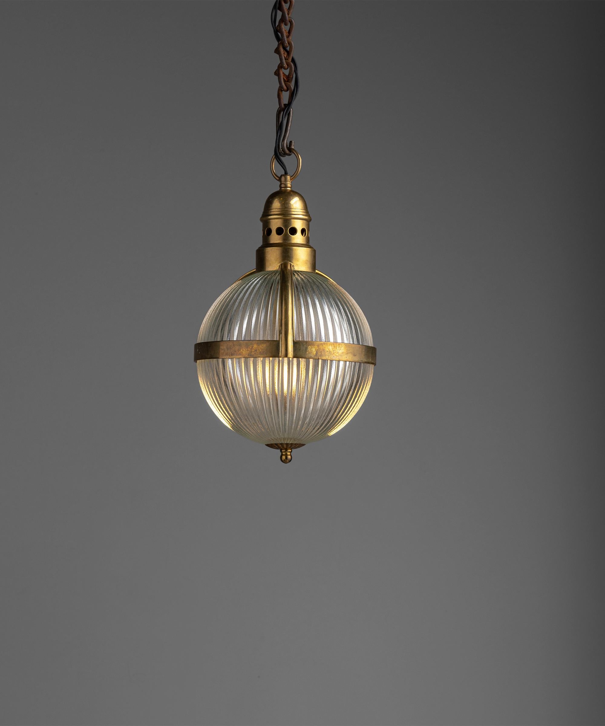 Small Holophane globe pendant.

England, circa 1950

Two-part Holophane fixtures with brass cage and fitter.