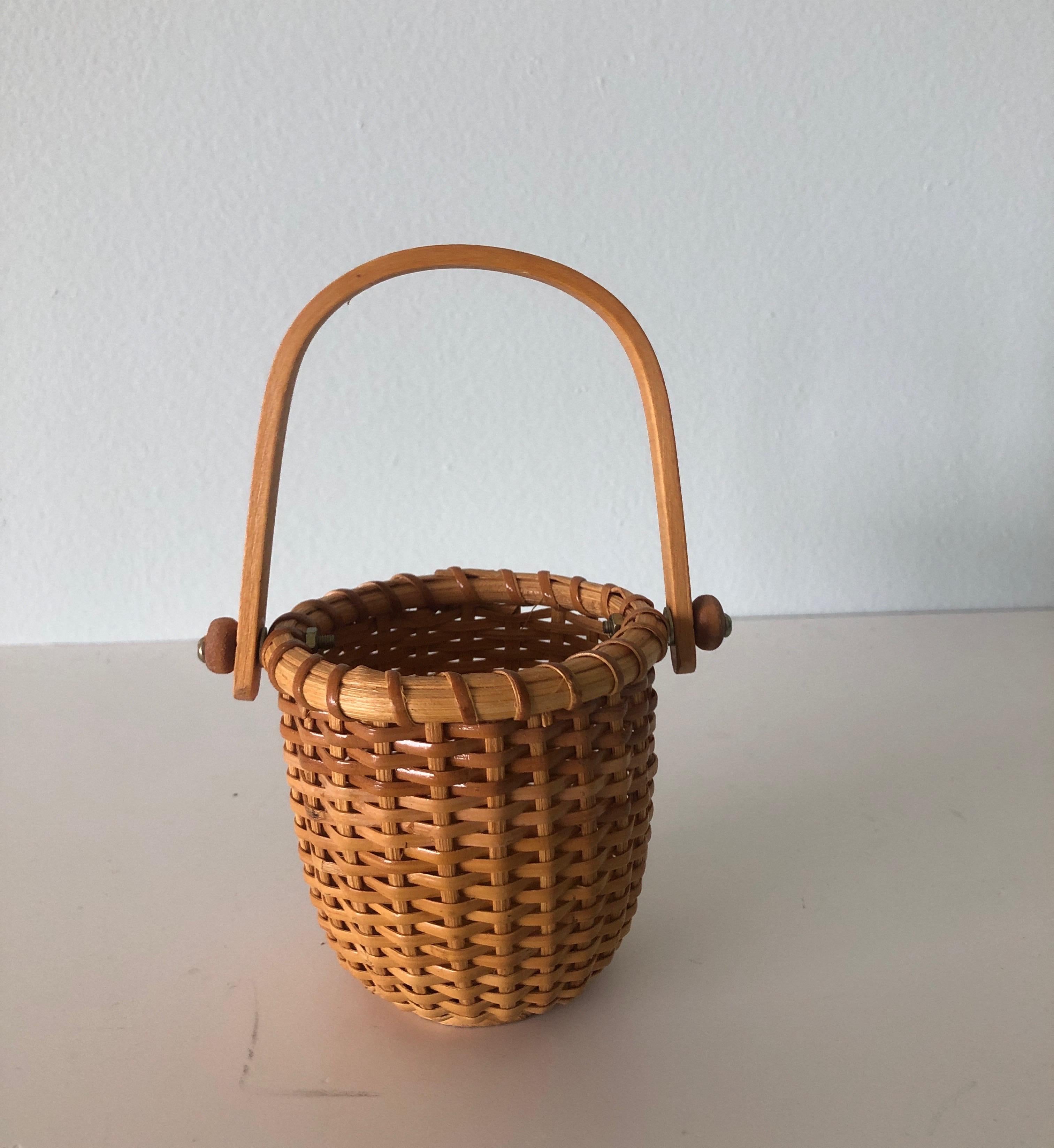 Small honey color woven decorative basket
with wooden handles and wood base
Size: 4” D x 6” H.