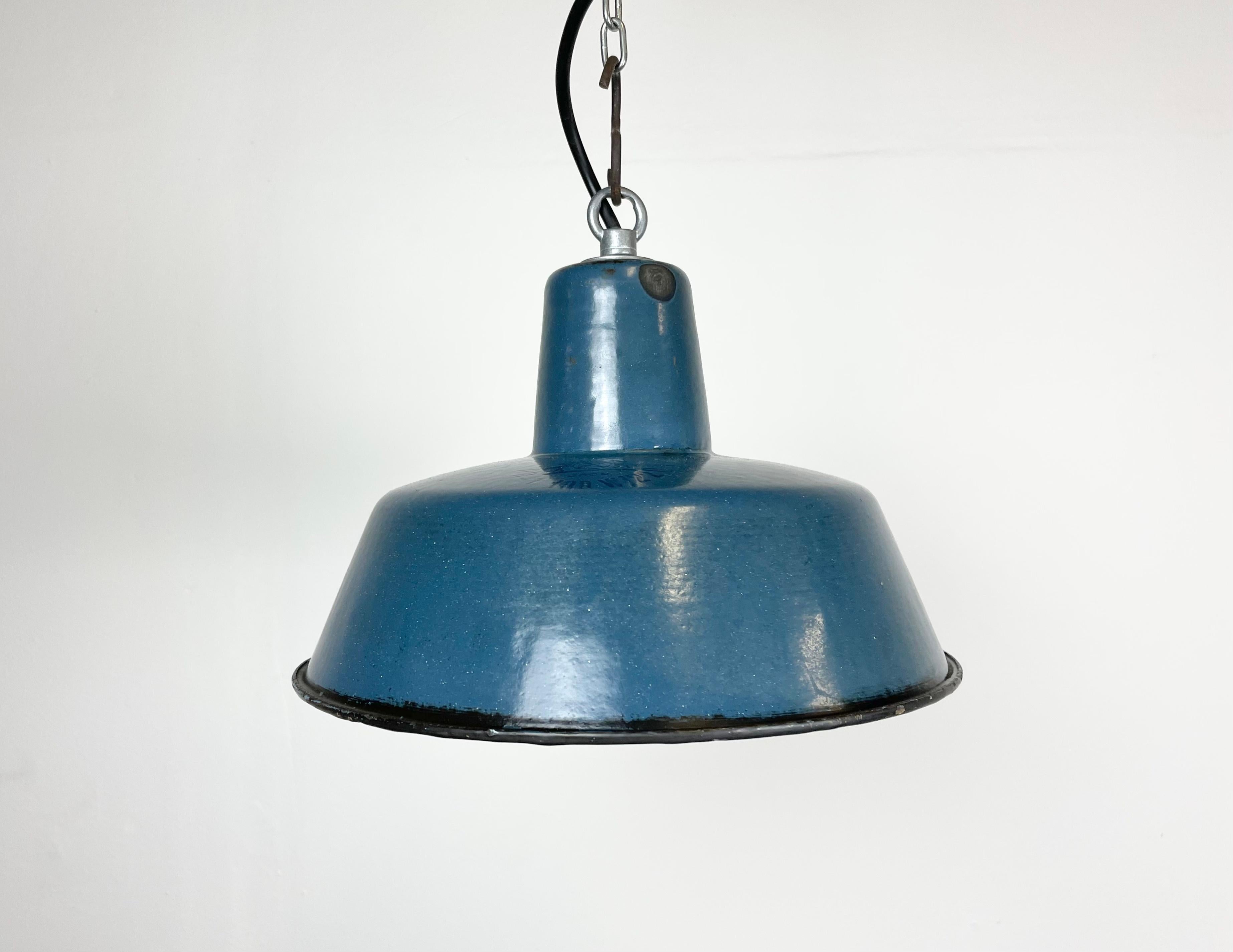 Industrial blue enamel pendant light made in Poland during the 1960s. White enamel inside the shade. Iron top. The porcelain socket requires E 27 light bulbs. New wire. Fully functional. The weight of the lamp is 0,8 kg.