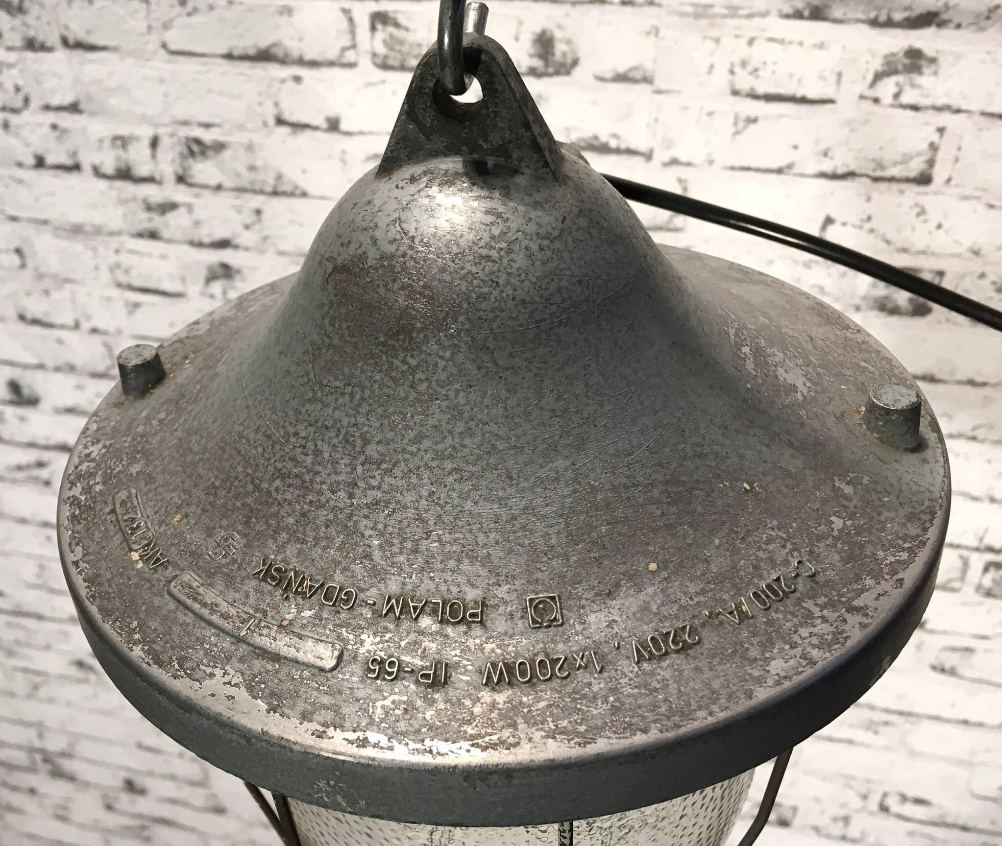 Grey polish industrial lamp with a wired protective glass bulb. Cast aluminium  body. Iron cage. Very good vintage condition. Porcelain socket for E27 bulbs. Newly wired. Made by Polam Gdansk.