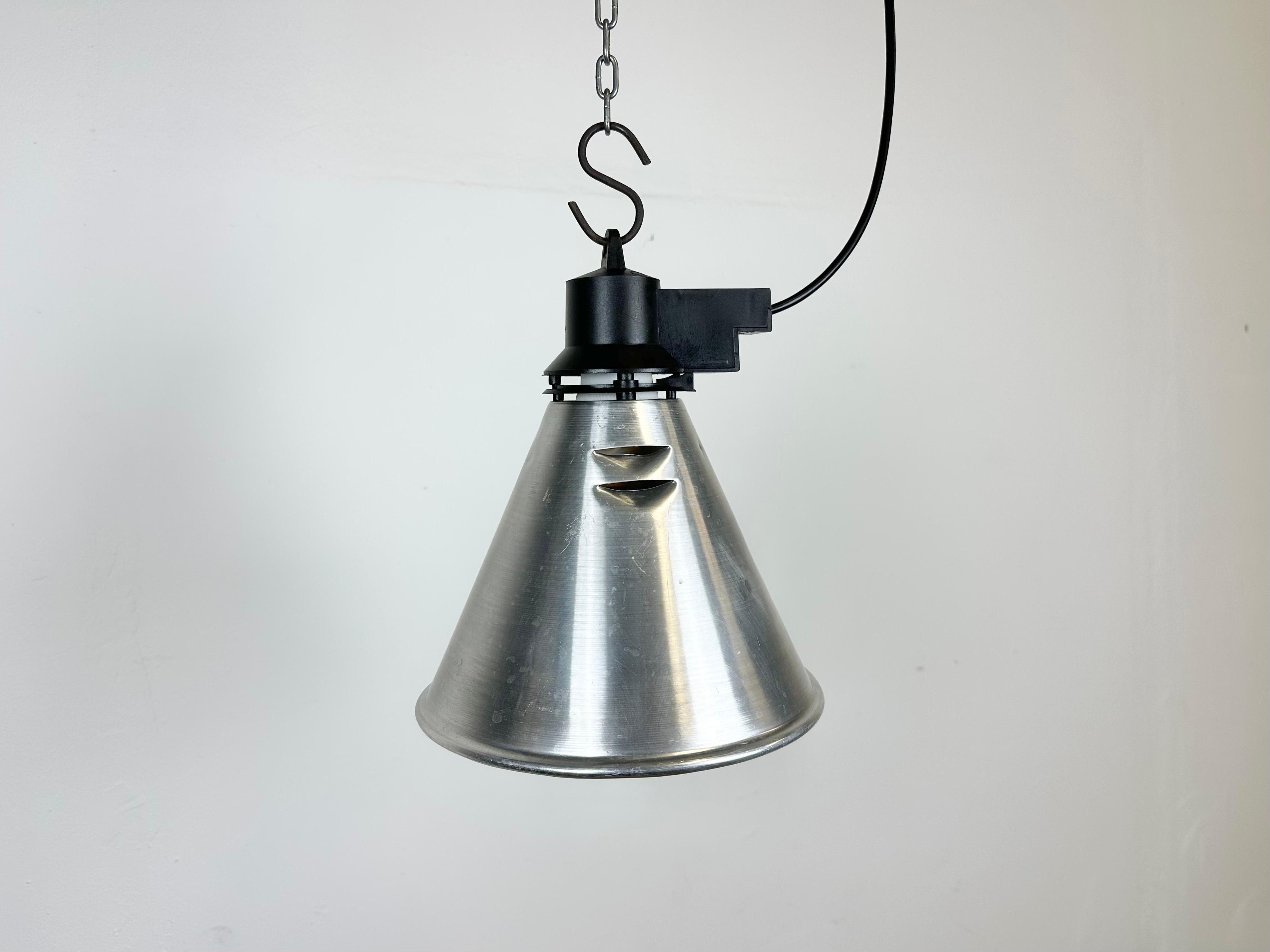 Small Industrial factory pendant light made in France during the 1960s. It features a silver aluminium shade and a black bakelite top  .The porcelain socket requires standard E 27/ E26 light bulbs. New wire. Fully functional. The weight of the lamp