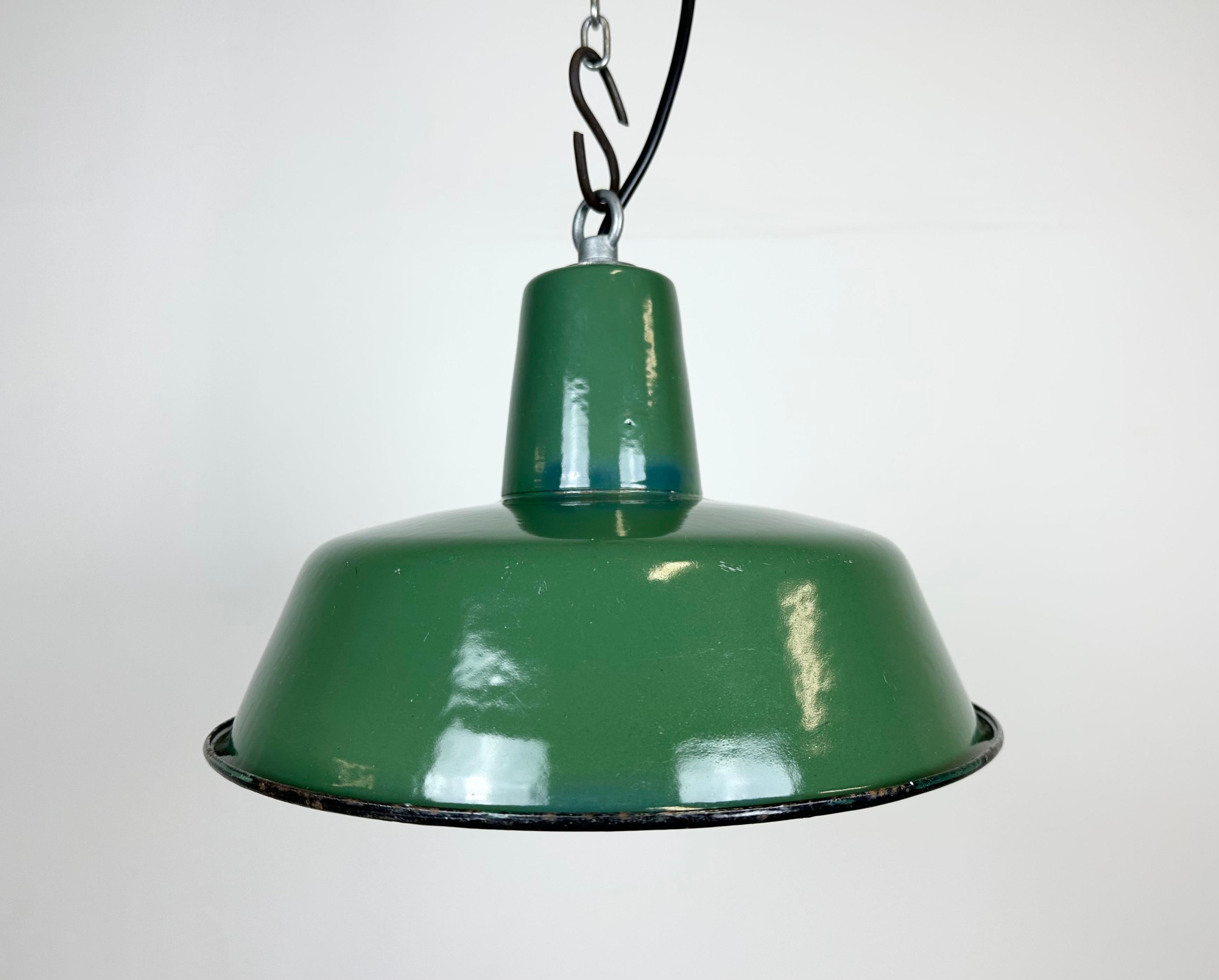Industrial green enamel pendant light made in Poland during the 1960s. White enamel inside the shade. Iron top. The porcelain socket requires E 27/ E 26 light bulbs. New wire. Fully functional. The weight of the lamp is 0,8 kg.