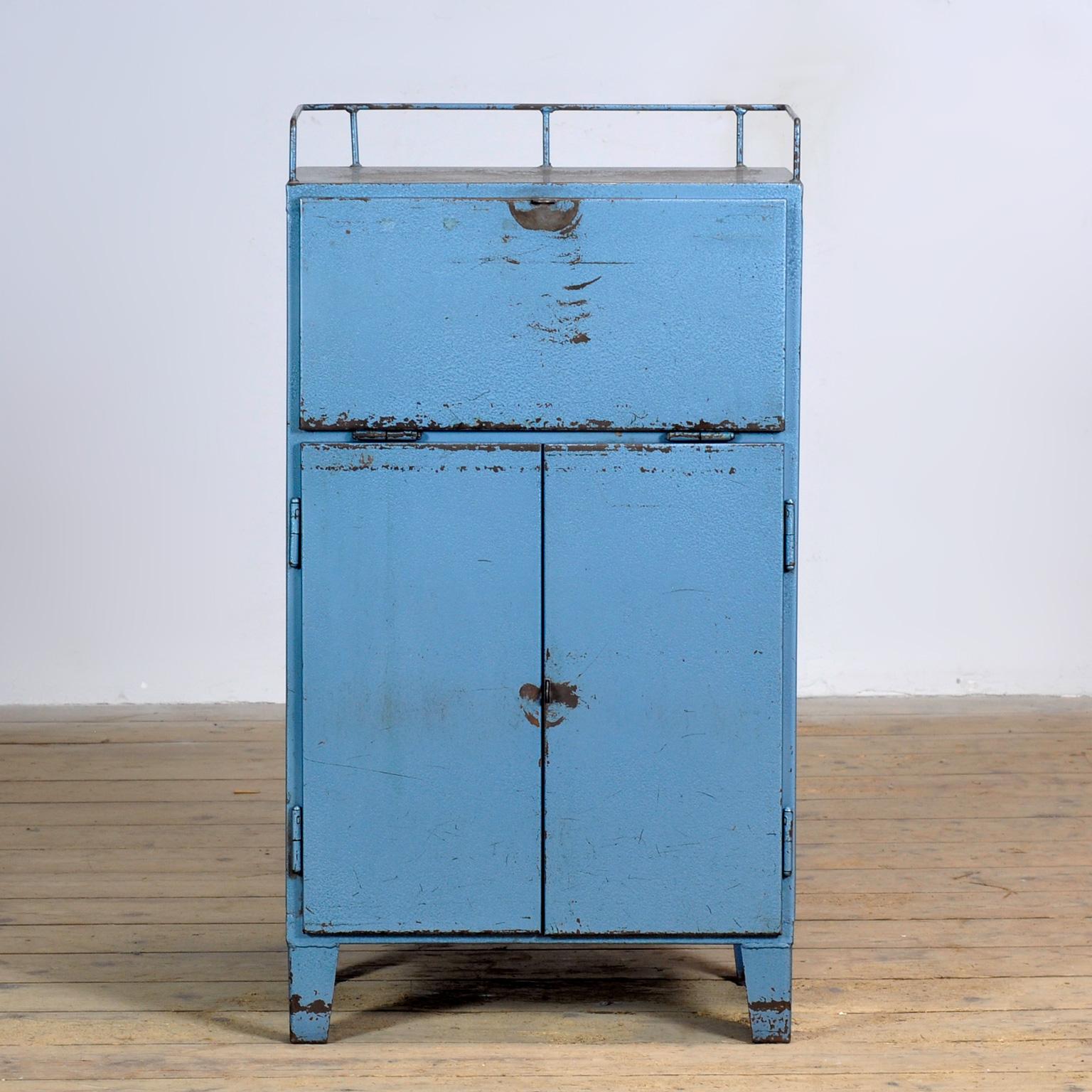 Armadio industriale degli anni '70, realizzato in ferro con vernice originale. Con quattro cassetti e un ripiano all'interno e uno sportello sulla parte superiore.