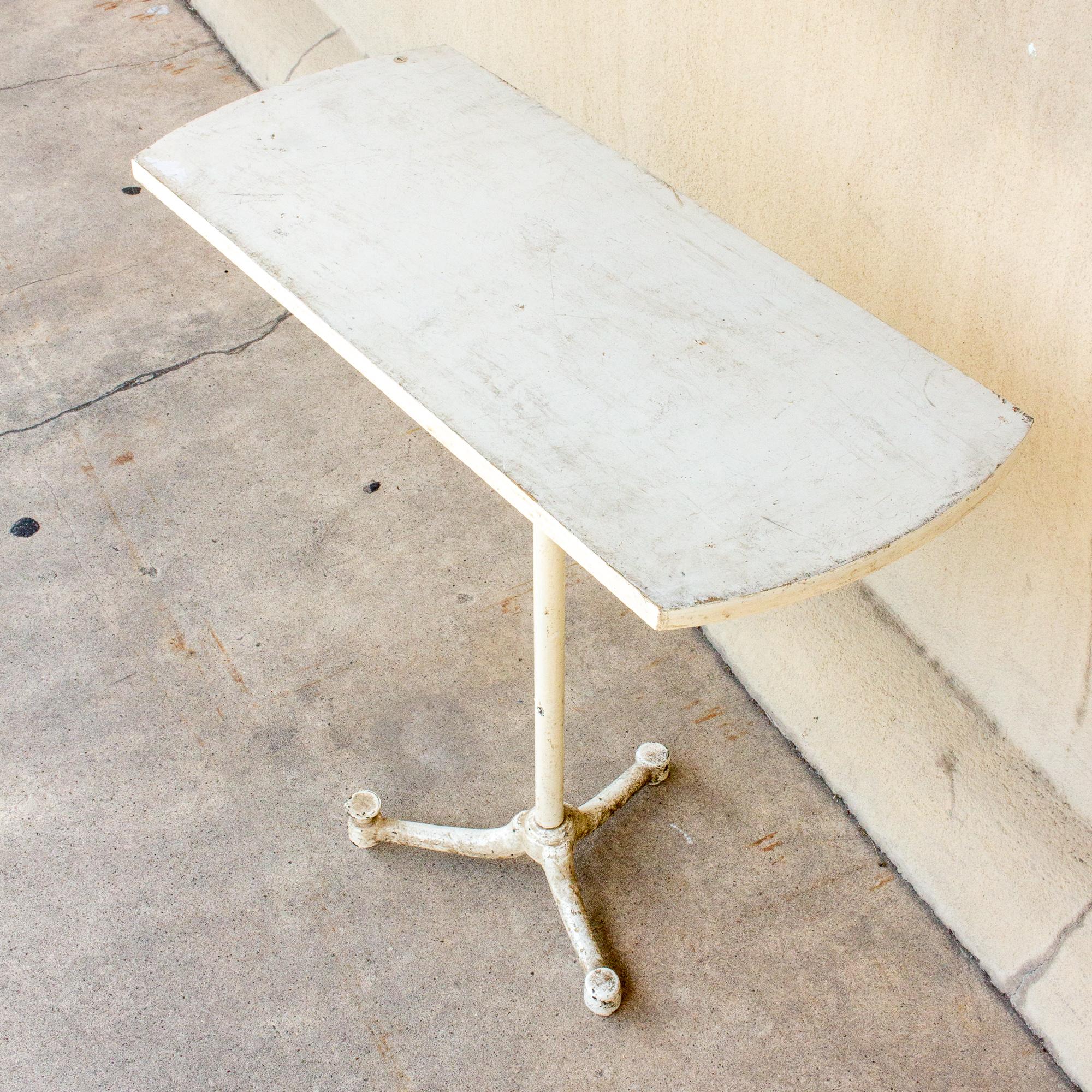 This is a petite side table or console we sourced in France. The top is wood and the base is an iron piece which looks almost like iron pipe used in plumbing. The piece has tripod-feet branching out from the base. Although small it speaks