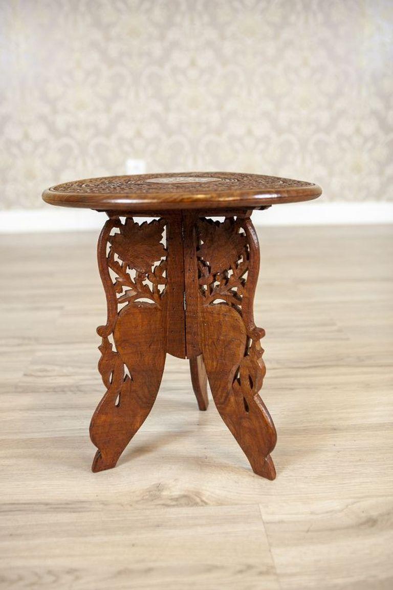 Small Inlaid Side Table From the Early 20th Century in light brown

A small table with floral marquetry, featuring four openwork legs and a round top, both adorned with floral motifs. The tabletop is slightly uneven.