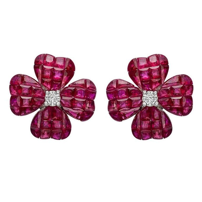 Clover stud earrings, designed as an invisibly-set calibre-cut ruby clover centering a round brilliant-cut diamond, mounted in 18k white gold. Rubies weighing 11.14 total carats and two diamonds weighing 0.20 total carats. Posts with friction backs