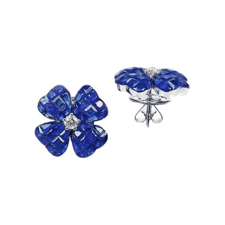 Four-leaf clover stud earrings, designed as an invisibly-set calibre-cut sapphire clover centering a round brilliant-cut diamond. Handcrafted in polished 18k white gold. Sapphires weighing 11.15 total carats. Two diamonds weighing 0.20 total carats.