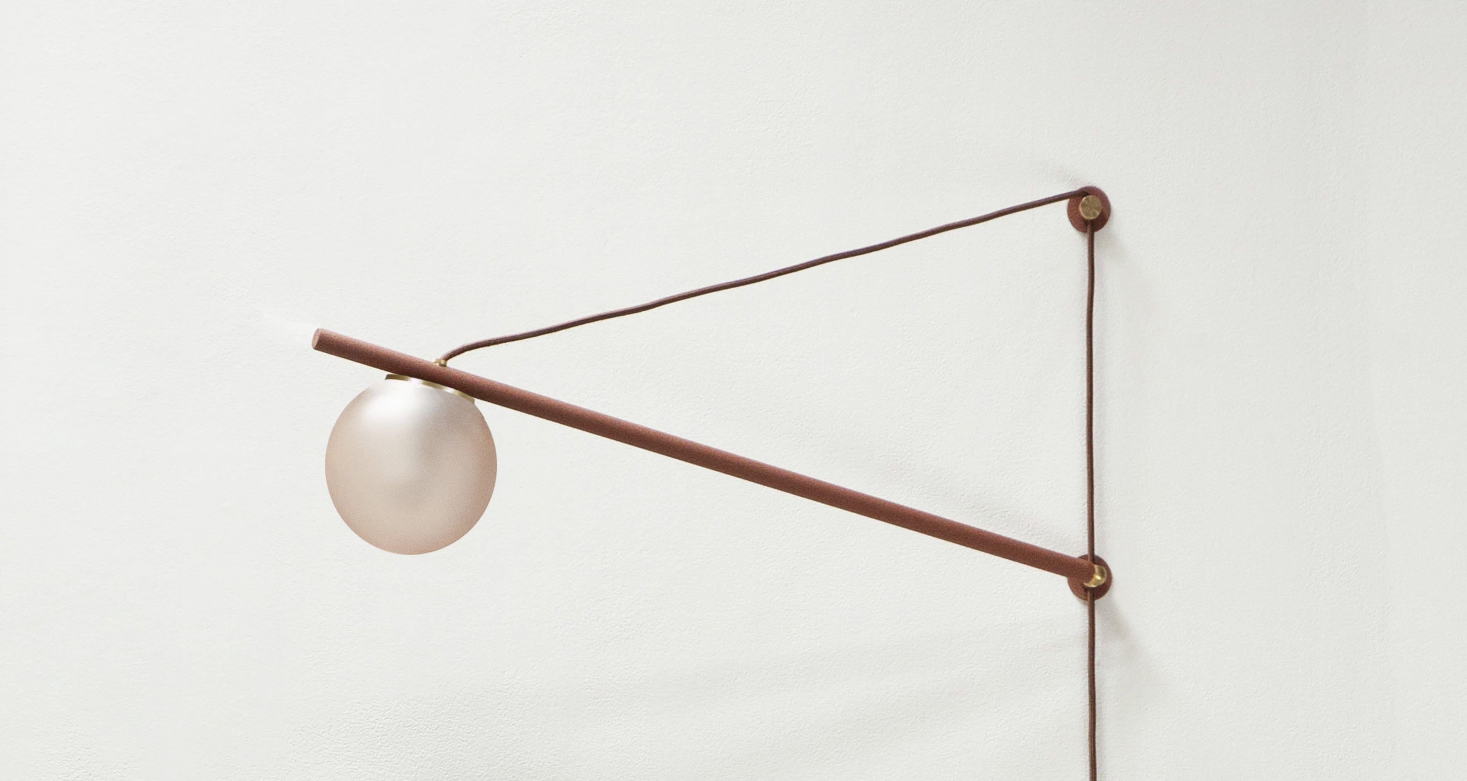 Small ISO sconce light by Ladies & Gentlemen Studio
Dimensions: H 17” x W 30”, 6” globe
Materials: Powder-coated steel (also available in brass), fabric cord, color washed acid etched glass globe. 
Colours: Brushed brass with pine cord, rust, fog