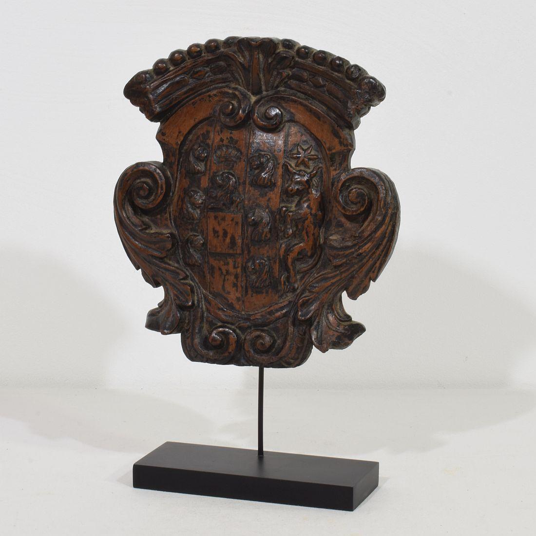 Gorgeous small hand carved wooden coat of arms with several lions heads, a crown and a standing bull,
 Italy, circa 1650- 1750. 
Weathered, small losses and old repairs. Measurement includes the base.