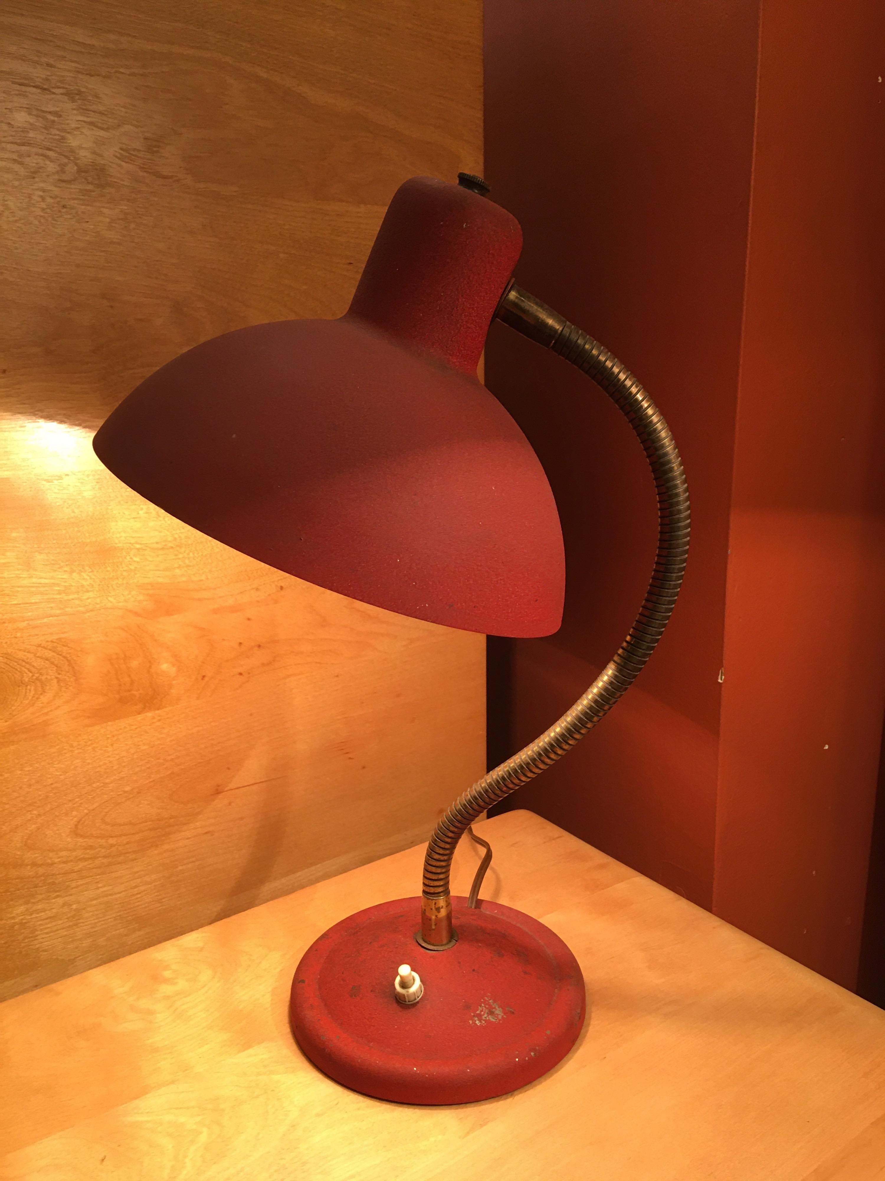 Small Italian table or desk lamp retaining its original red paint and on/off switch. Goose neck design allows for multiple positions. Base and shade has a textured paint finish. Goose neck is in a brass material.