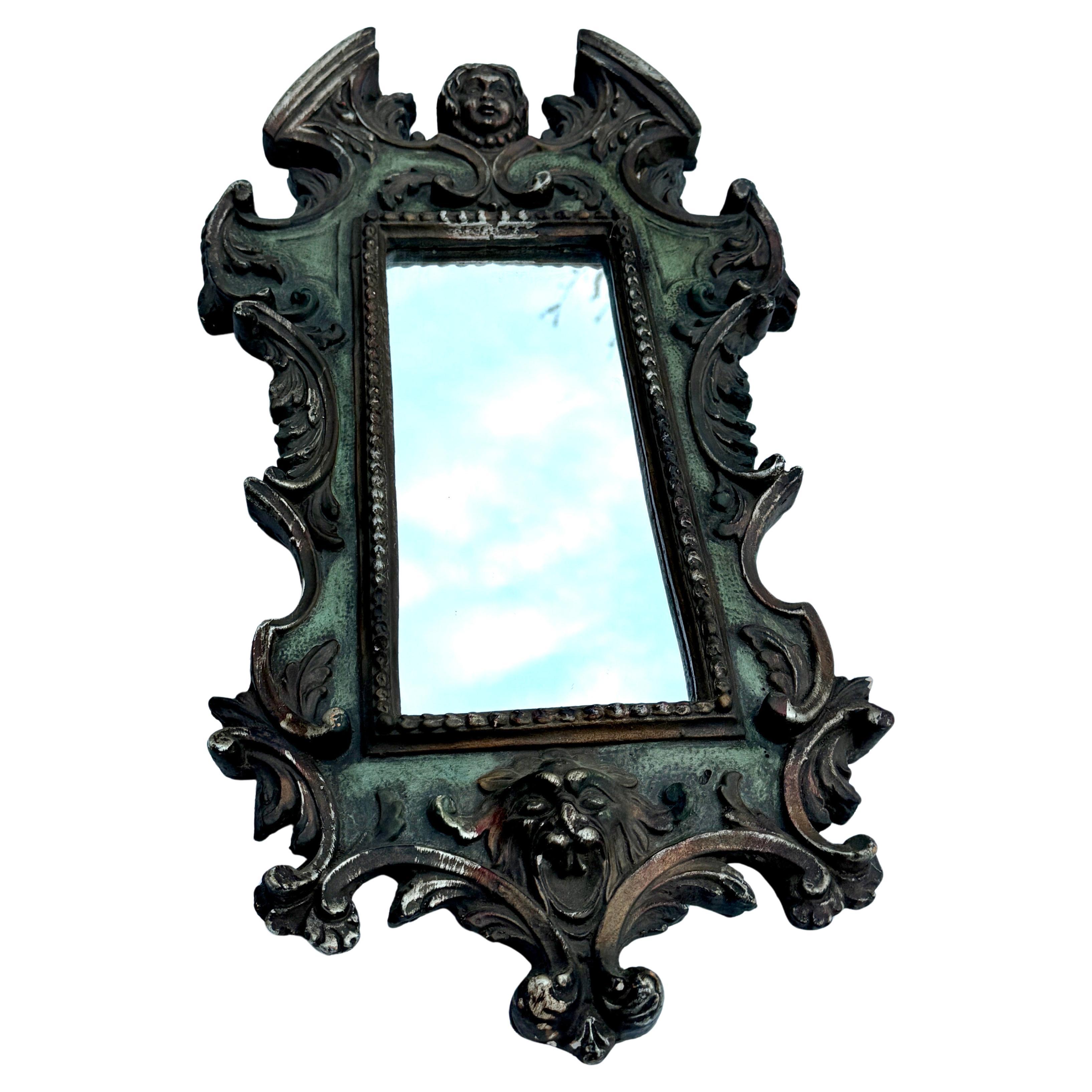 Late 19th Century Italian Baroque-Style Gilded Wall Mirror

Elegant carved wall mirror characterized by elaborate decorations including Italian puttis. The color of the mirror is green with darker accents coming through. This mirror is a very