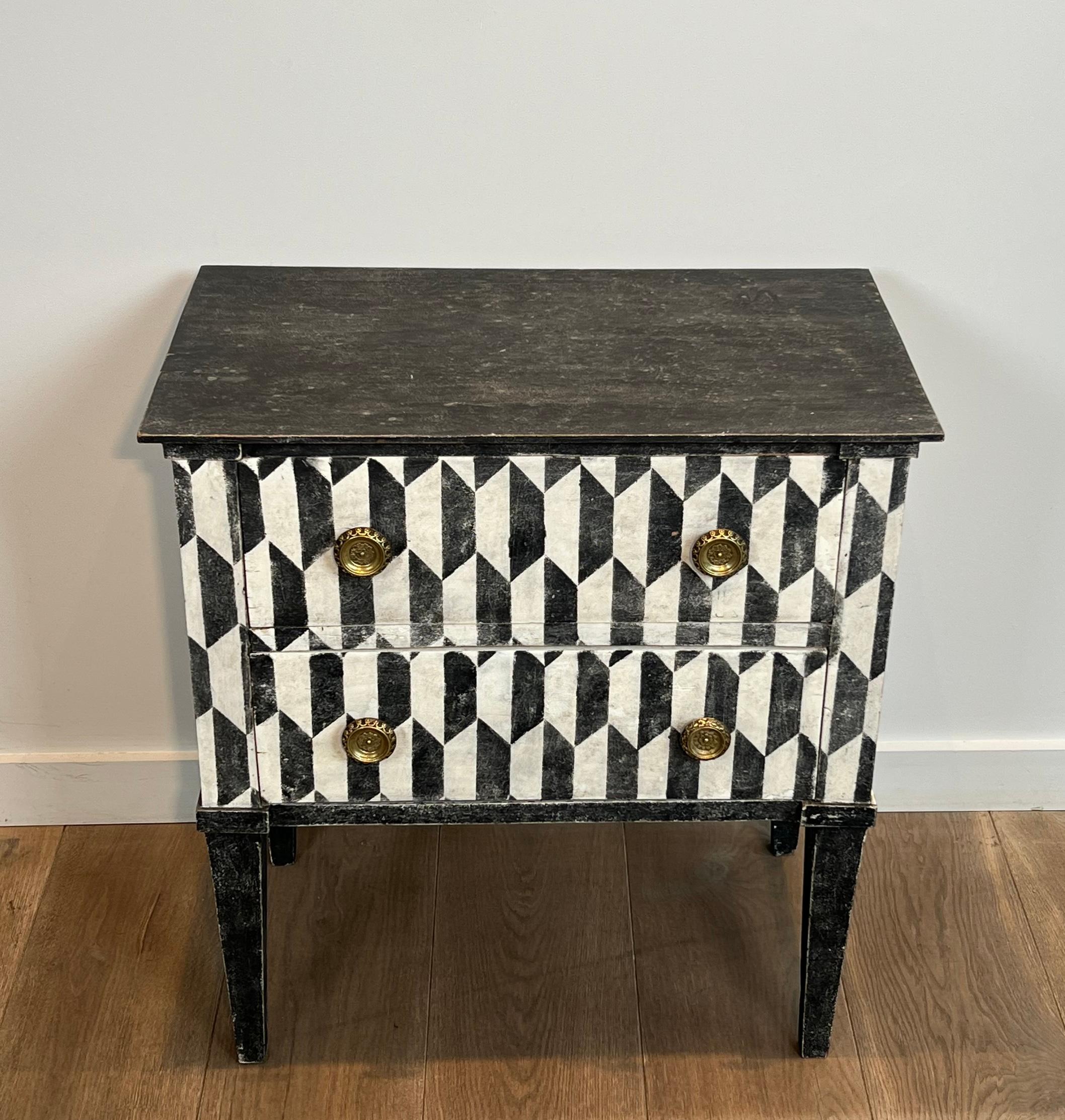 Cette très belle et très décorative petite commode à deux tiroirs est constituée d'un damier patiné en trompe-l'œil. Il s'agit d'une œuvre italienne. Circa 1850