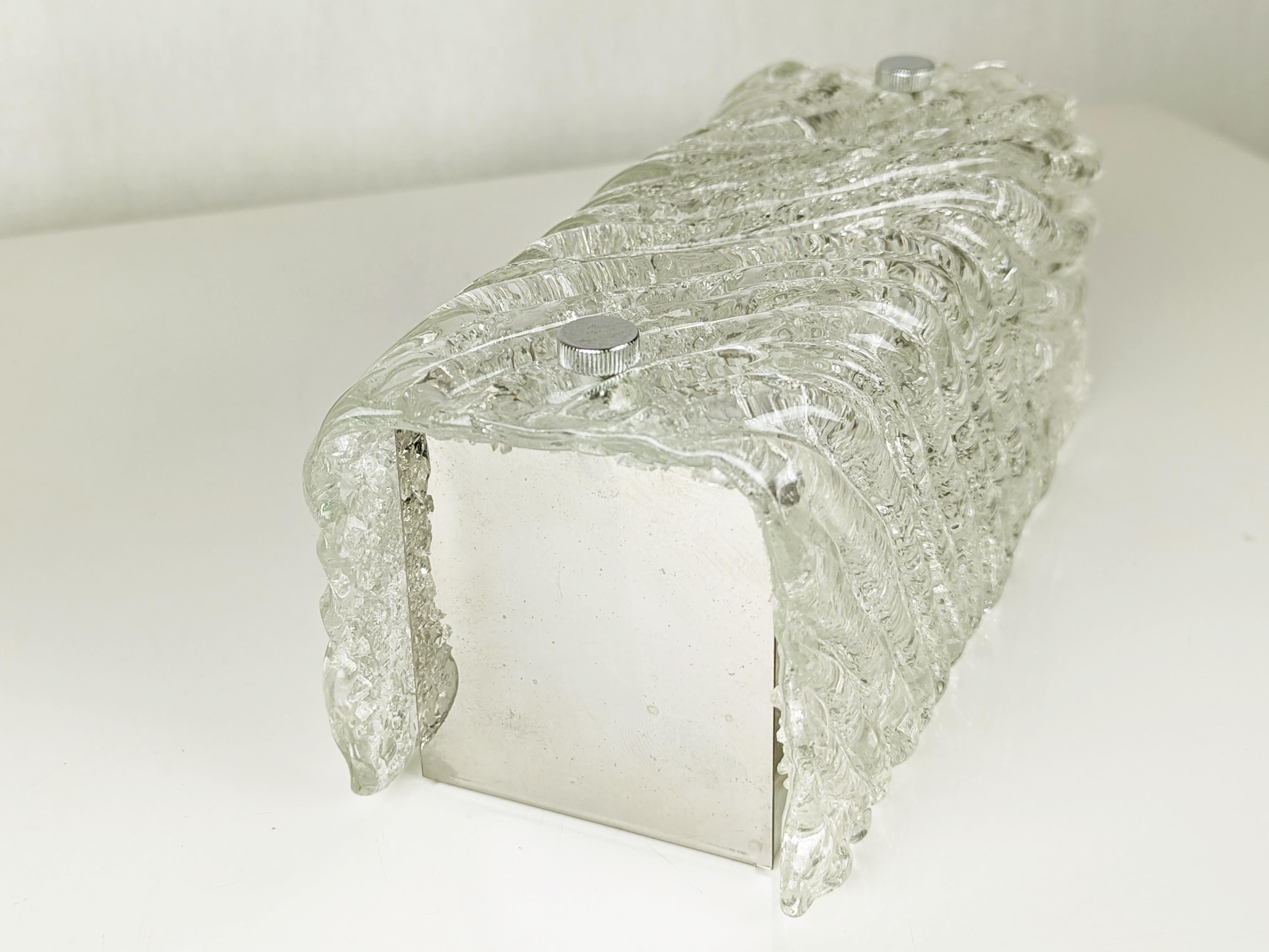 Petite applique ou plafonnier composé d'un abat-jour en verre clair de Murano et d'une structure en métal chromé. 
La qualité du verre rappelle les produits similaires fabriqués par Venini. Cette lampe est équipée d'une douille E27.
Très bon état