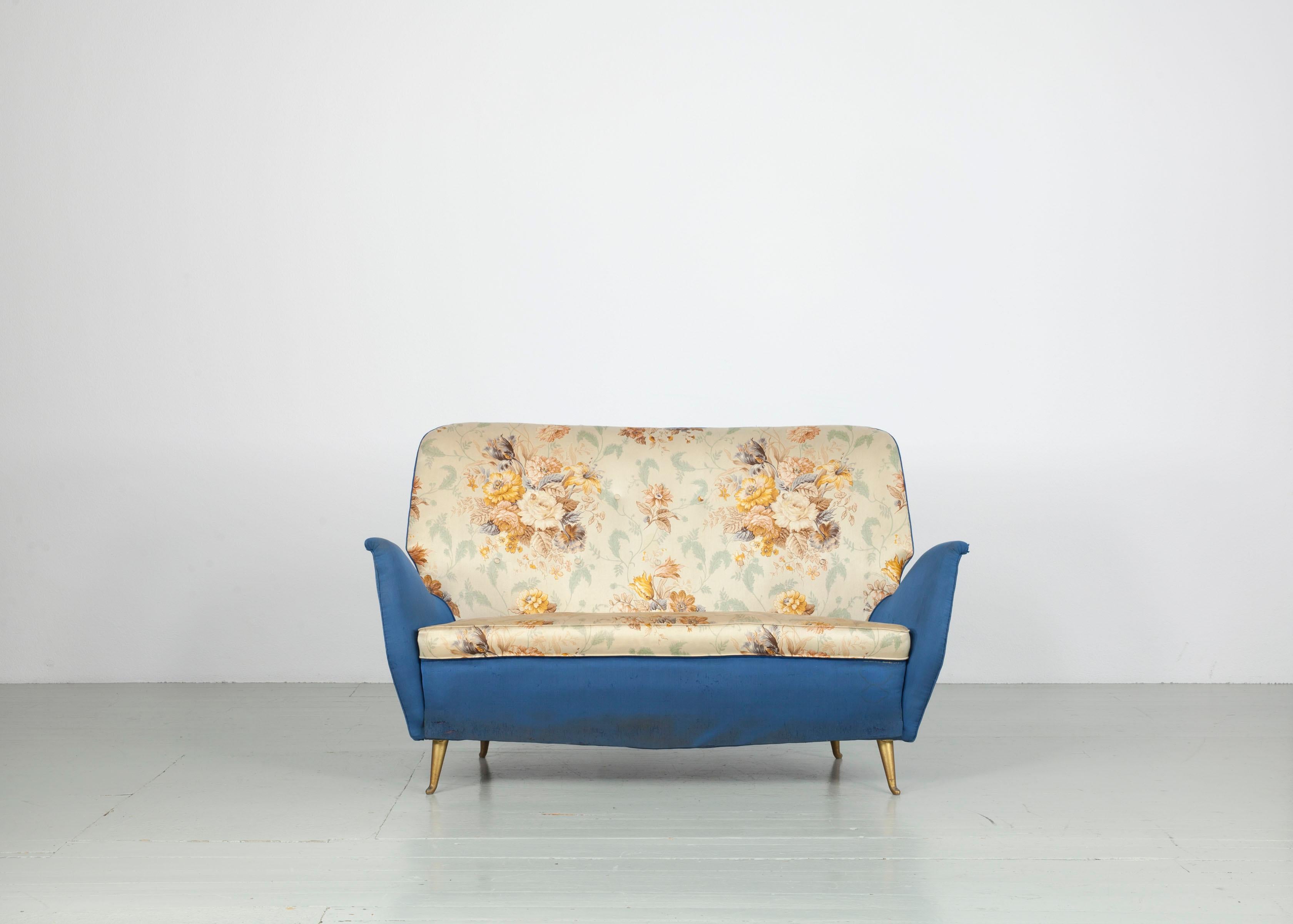 This sofa was made in Italy in the 1950s by I.S.A. Bergamo. The sofa is upholstered in blue fabric and cream fabric with a floral motif on the seat and backrest. The body of the piece of furniture rests on fine, golden iron casted legs. The sofa is