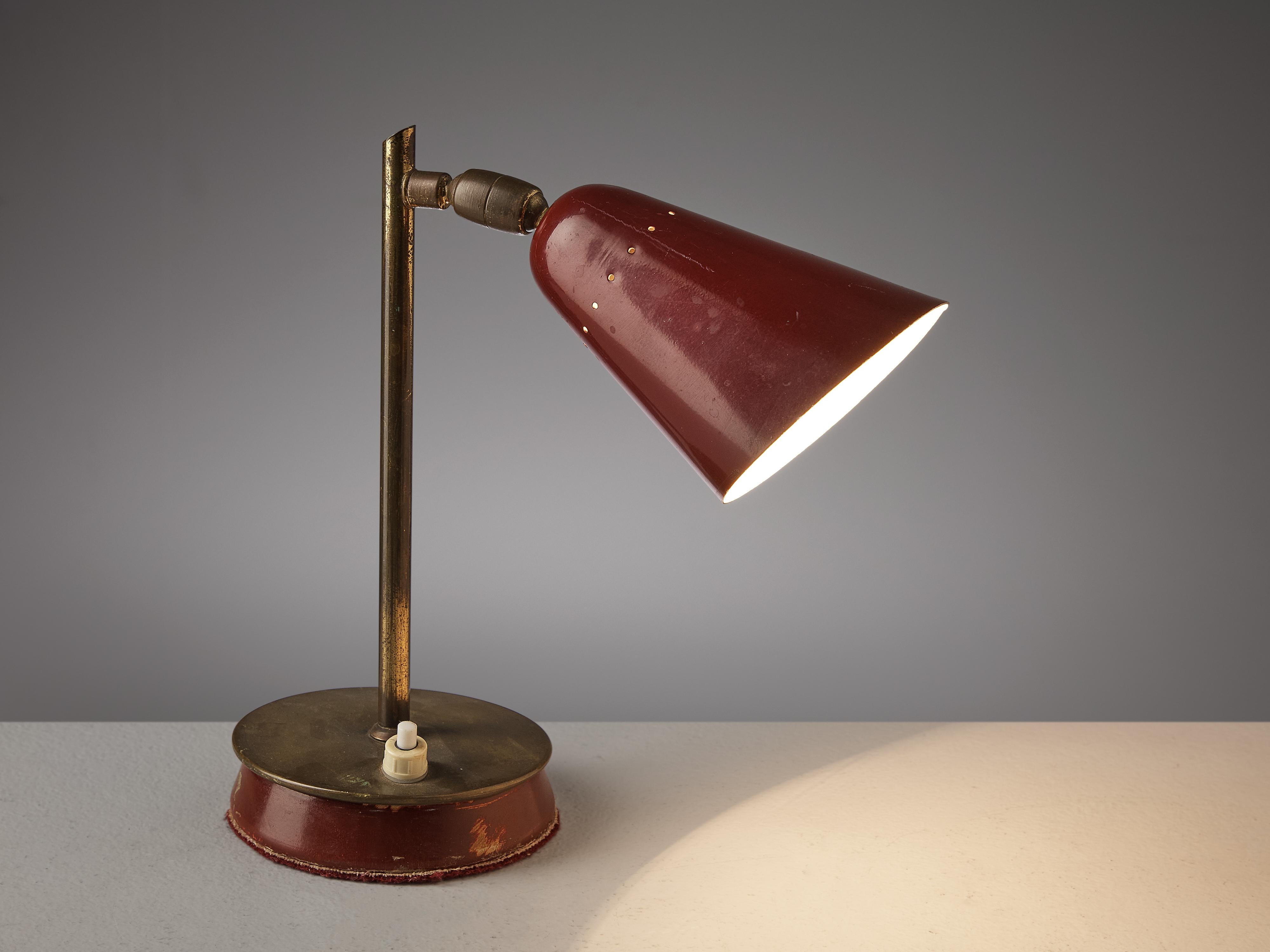 Table lamp, brass, aluminum, metal, Italy, 1960s.

This table desk lamp is stunningly executed in brass with a red color. It features a simple yet nice shade in a bright red color. The base of this is a round made out of brass together with the