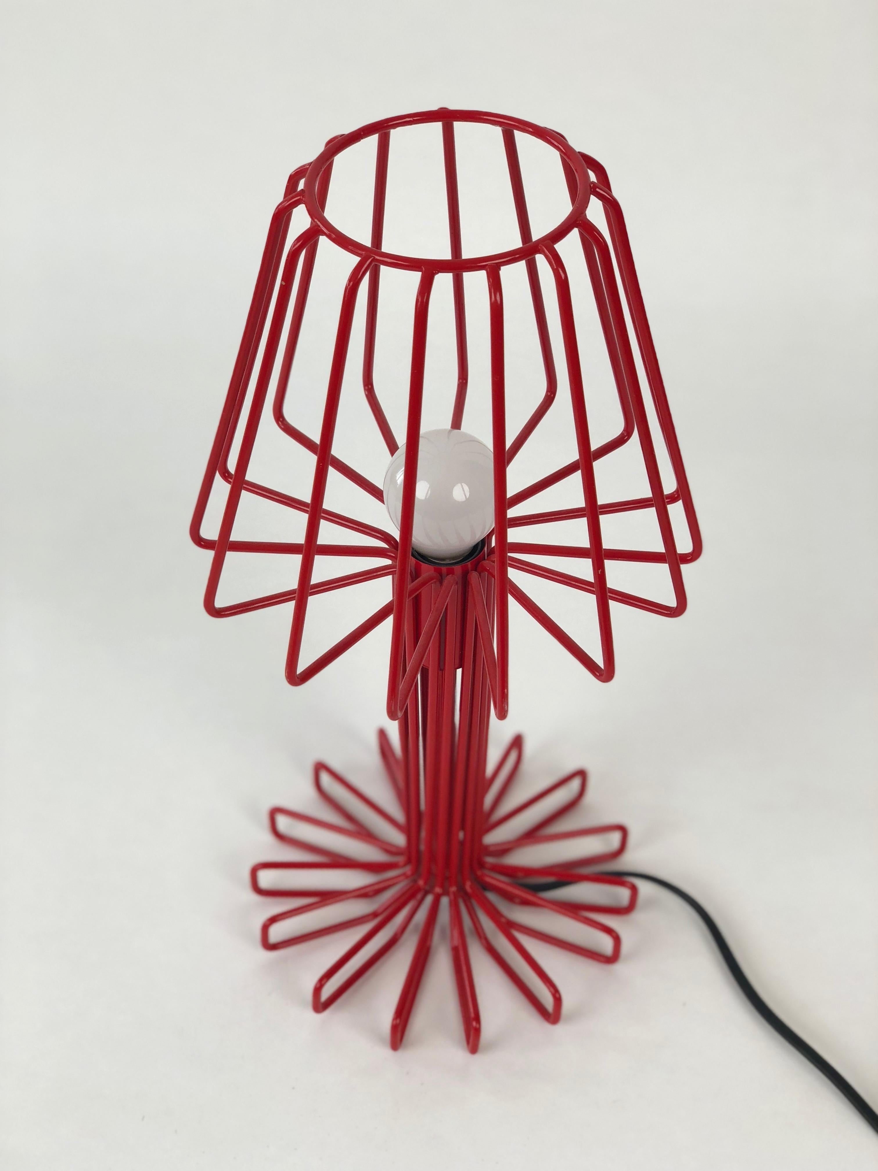 Cette lampe de table est fabriquée en métal massif, laqué rouge pour une lumière de 25 Watt.