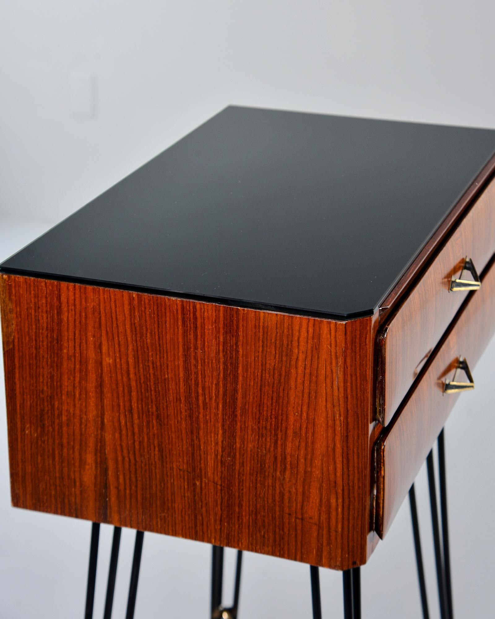 Italian side cabinet features slender black iron hairpin legs with brass capped feet, brass X-form stretchers and two-drawer cabinet in nicely figured wood veneer, circa late 1950s. Drawers have dovetail construction, original triangle form pulls