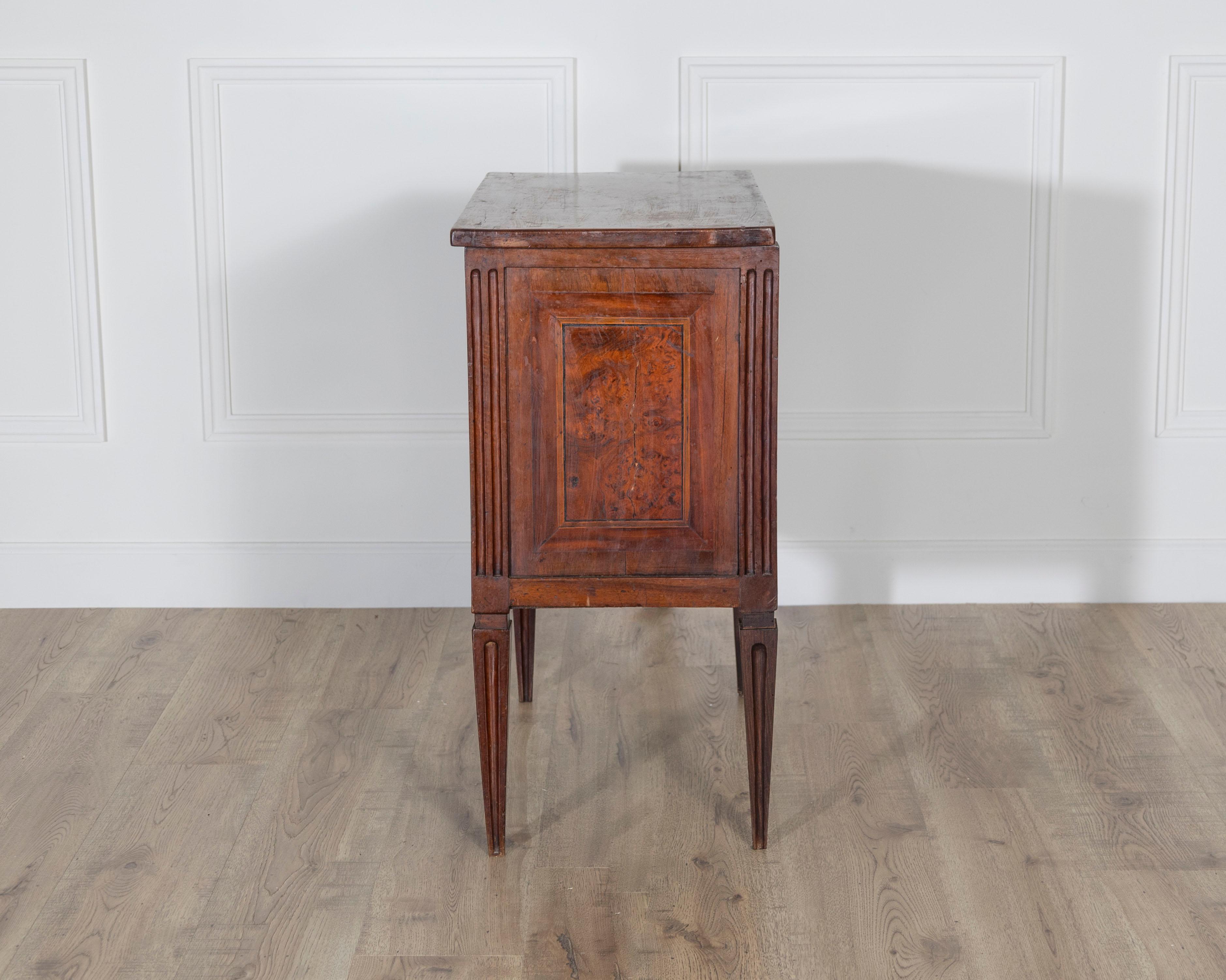 This small Italian chest of drawers combines refined proportions with timeless elegance, making it a versatile accent piece. Dating from the late 18th to early 19th century, the chest features two drawers adorned with gilt-bronze escutcheons and