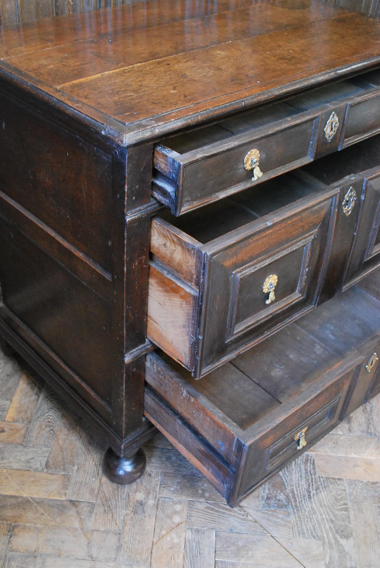 Hutton-Clarke Antiques is delighted to present a compact Jacobean oak chest of drawers dating back to the early 17th century. This exquisite piece features superb color and patination, resting gracefully on its original bun feet. The charm is