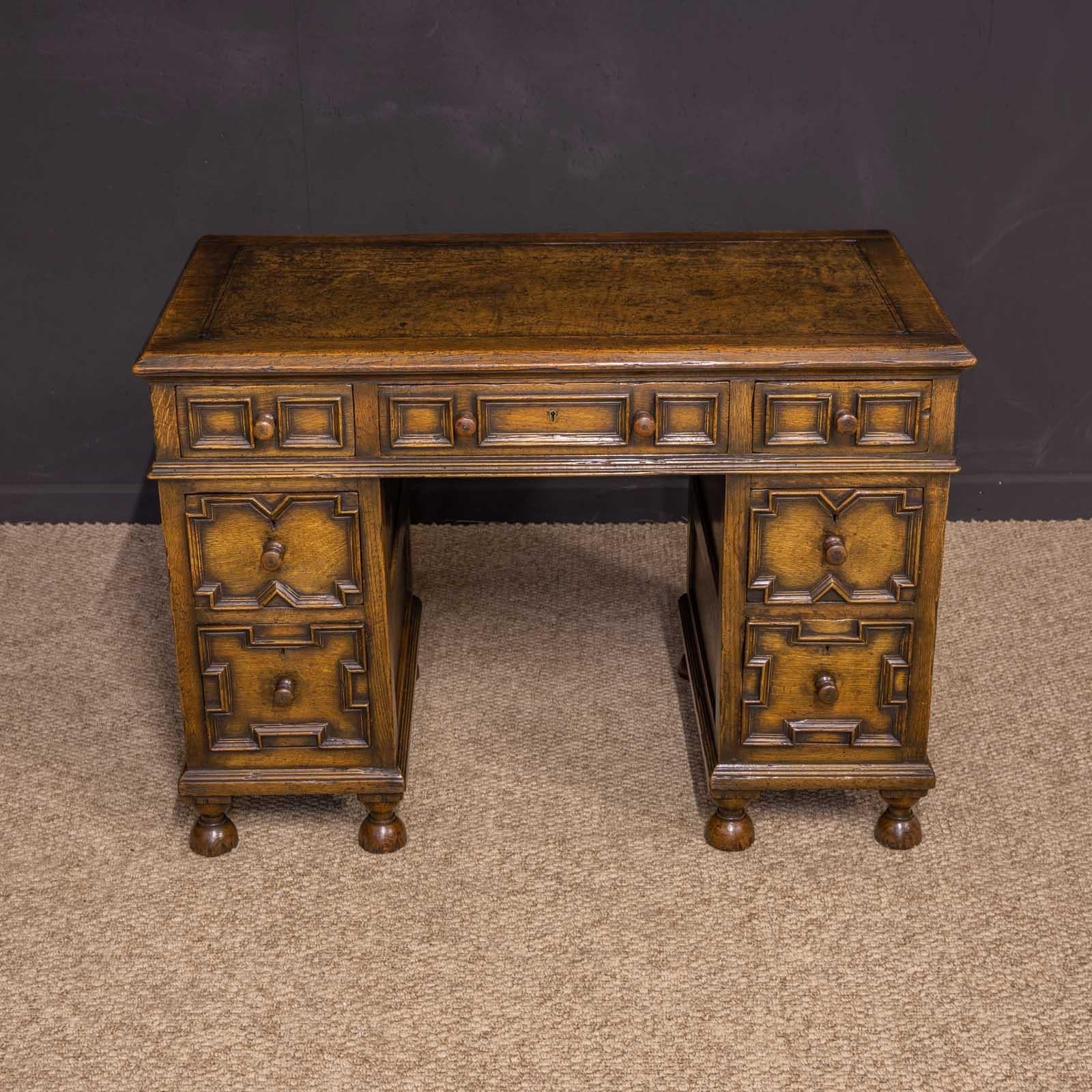 A superb quality and unusually small, writing desk, quite possibly by Titchmarsh and Goodwin. With the typical distressed look associated with the firm and use of solid oak throughout. Jacobean in style with geometric moldings to the drawer fronts