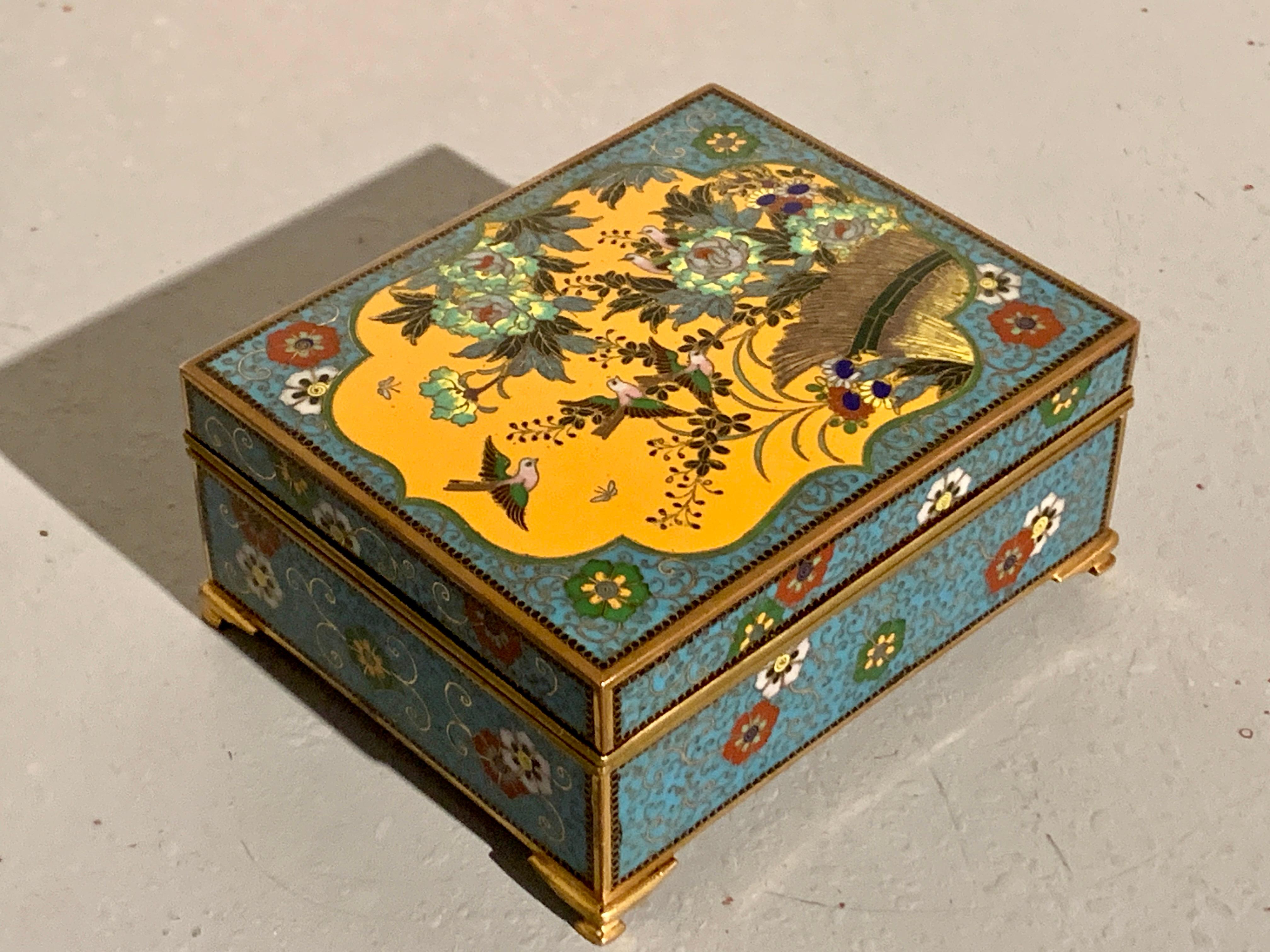 A charming Japanese cloisonne trinket or jewelry box by the Ando Cloisonne Company (Ando Shippo Ten), very late Meiji Period, circa 1910, Japan. 

The top of the box with a large mustard yellow ground quatrefoil reserve featuring a lovely design