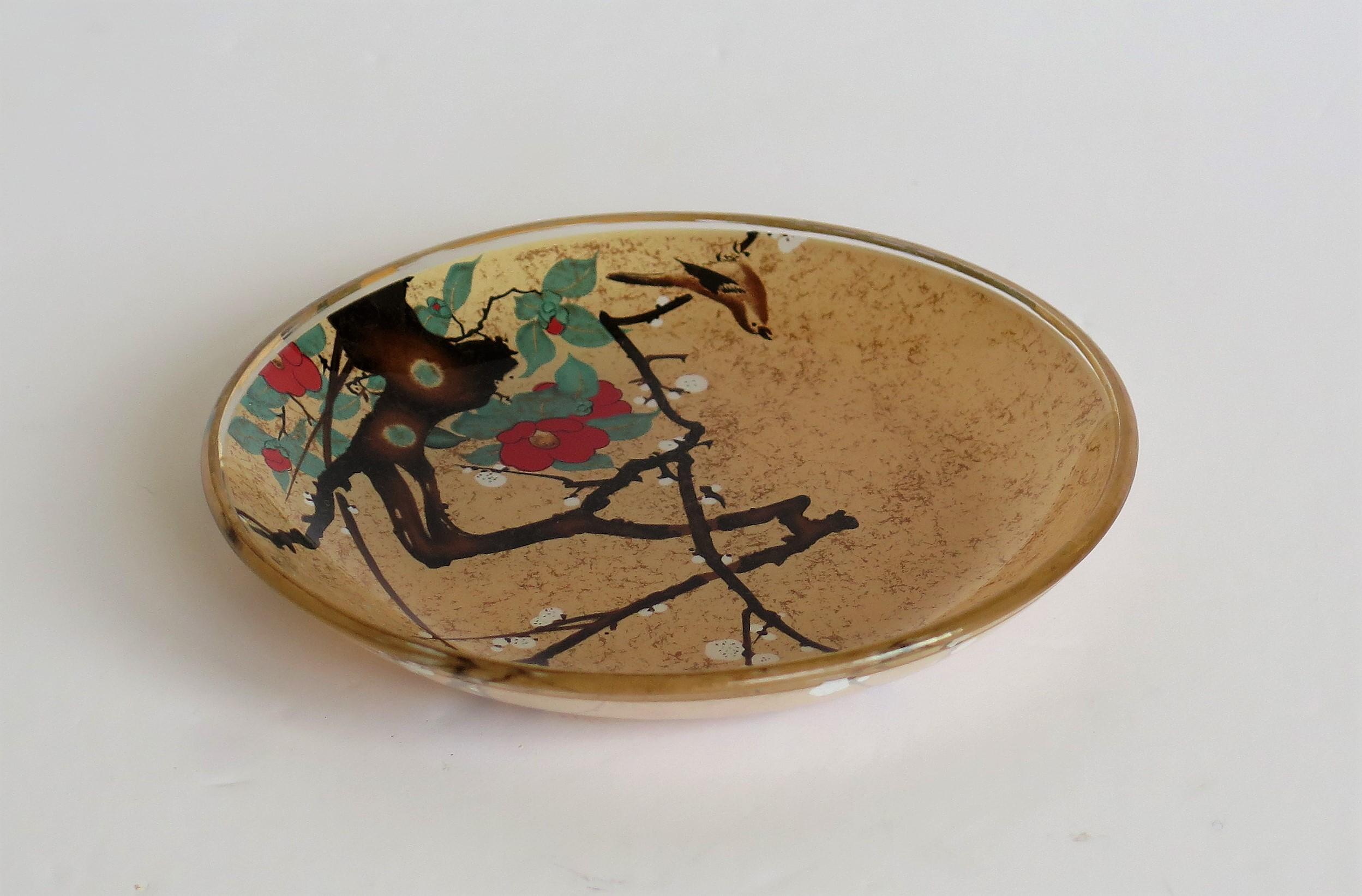 This is a small Japanese glass dish which is reverse hand painted in the Kakiemon style with a blossoming tree and perched bird which we date to the early 20th century, circa 1920

This is a small glass dish with a diameter of 4.5 inches.

It