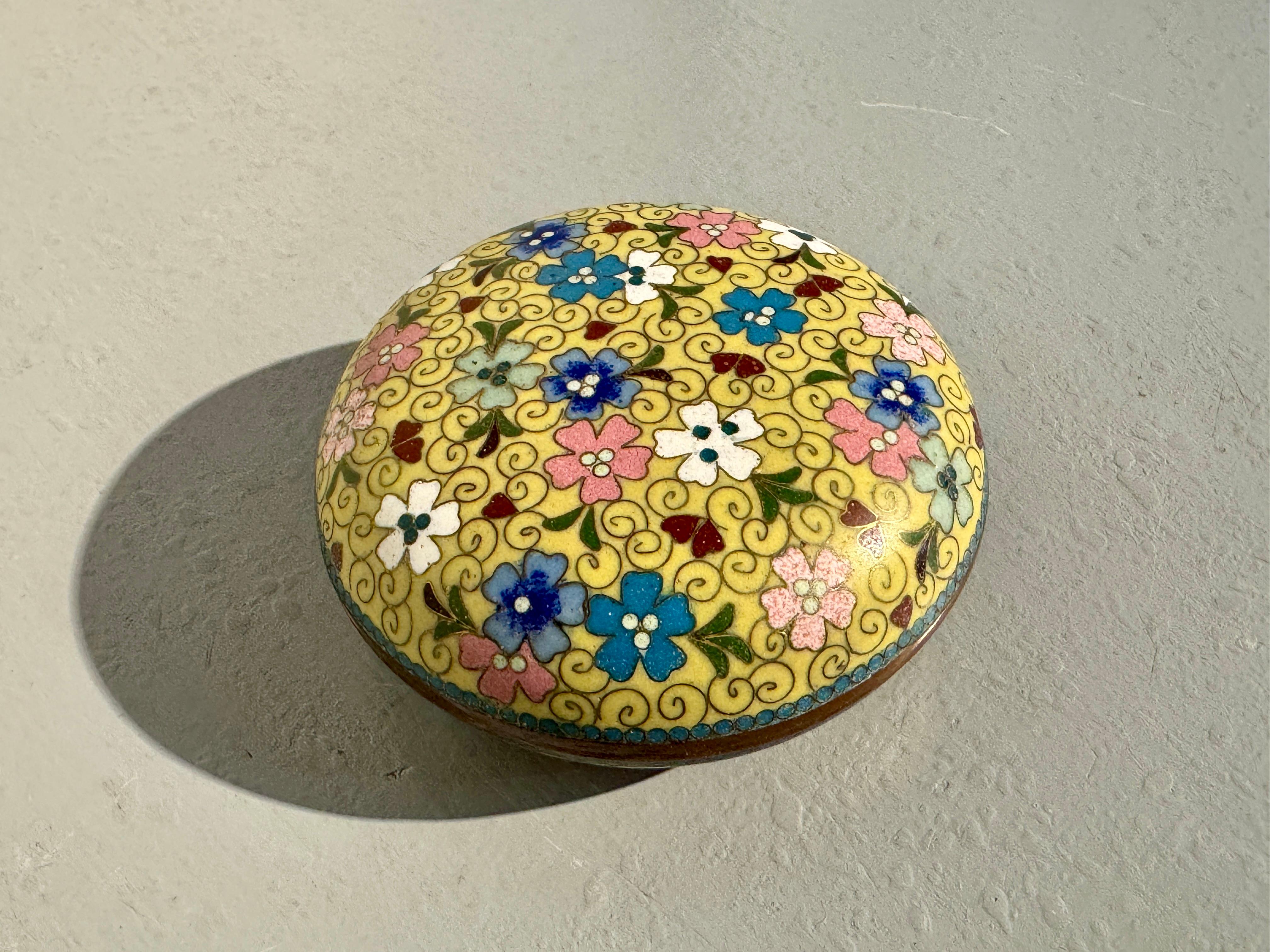 A small and delightful Japanese yellow ground cloisonne round trinket or incense box, Meiji Period, circa 1910, Japan.

The small box of squat, round shape, and may originally have been intended for use as a kogo, a container for precious