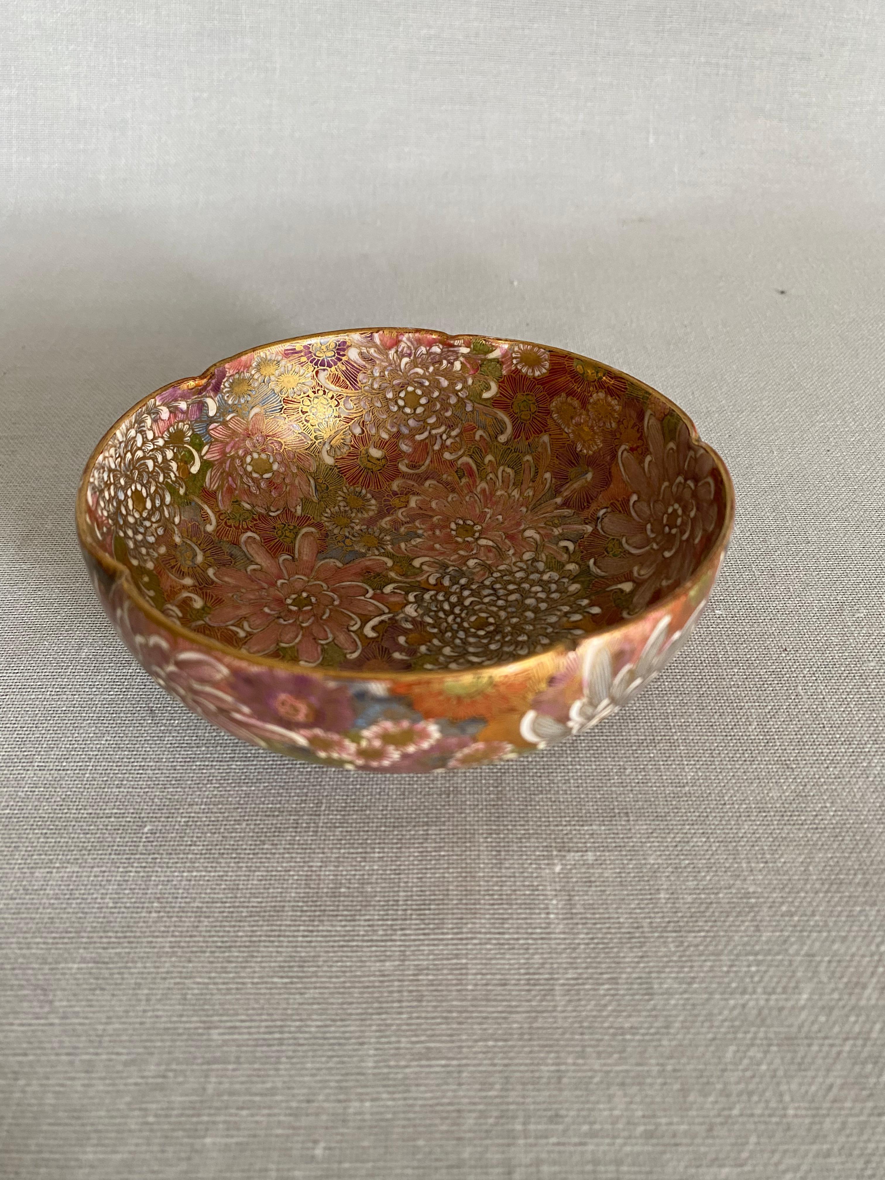 A round bowl decorated with various flowers, colorful chrysanthemum-filled ground emulating the Chinese style of porcelain known as mille fleur. Each leaf and detail with a fine gold outline.
Signed underneath with additional Shimanzu
