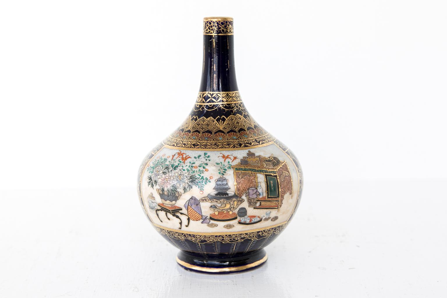 Small Japanese Satsuma vase, the panel on one side depicts various objects such as floral filled jardinieres, temple vases, urns, tea sets, and a bed. The other panel has multiple court figures in various poses. The borders above the panels have