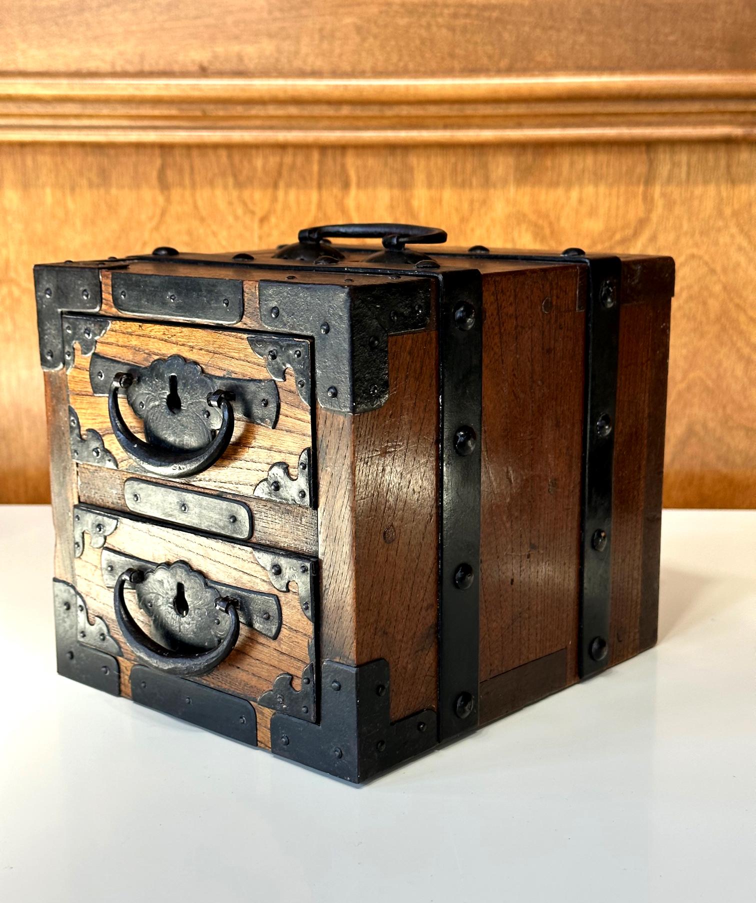 A small Japanese Zenibako (banker's money box) from early to mid-19th century circa late Edo Period. The chest was made from thick planks of a heavy hardwood with attractive grains and fitted with hand wrought iron hardware throughout. Made