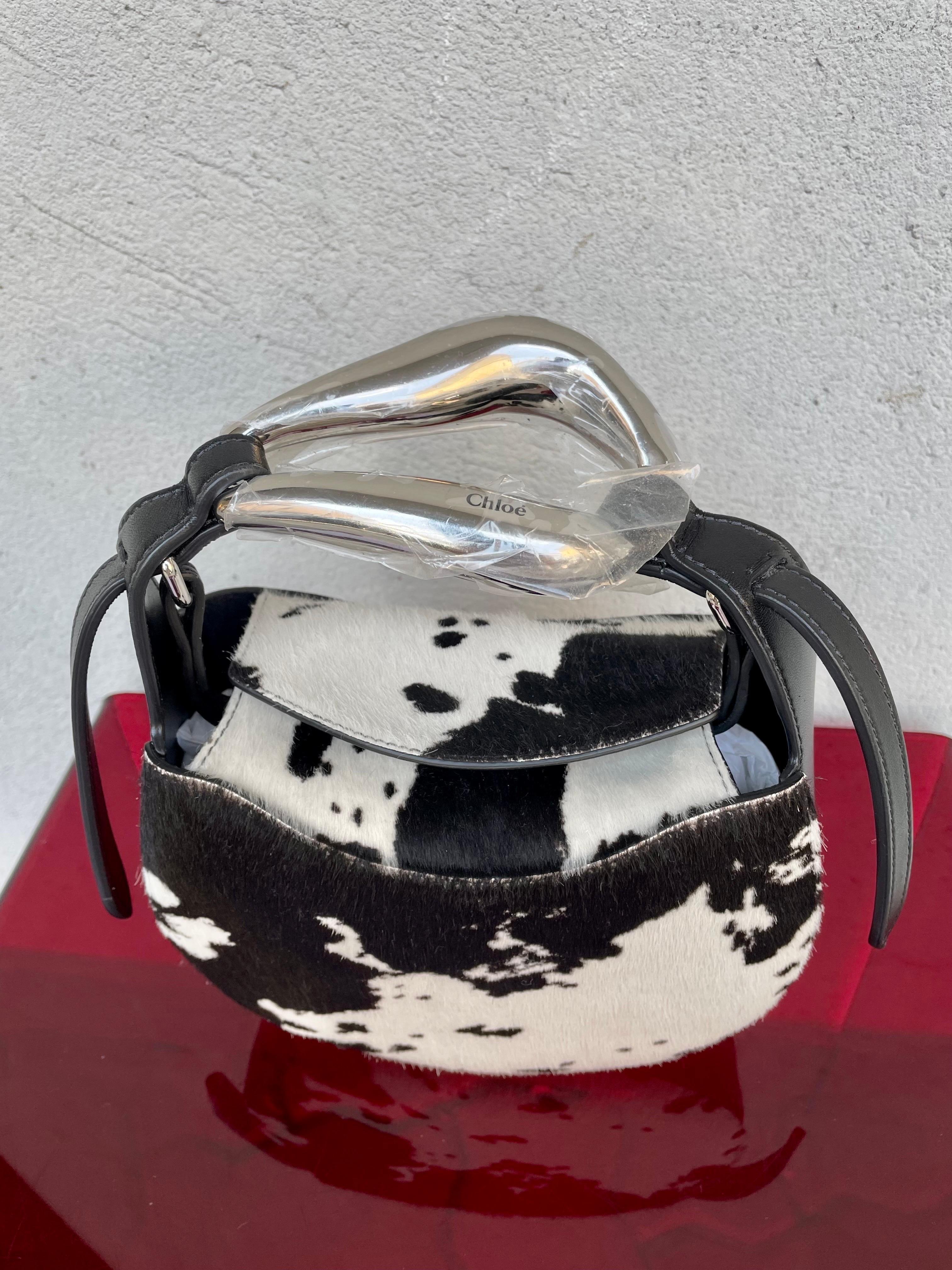 Small Kiss Chloe bag in pony-effect calfskin, to be worn over the shoulder or by hand. Hidden magnetic closure, sculptural handle in very light metal, emblem of the Kiss line, recalls the shape of a female mouth. Adjustable and removable shoulder
