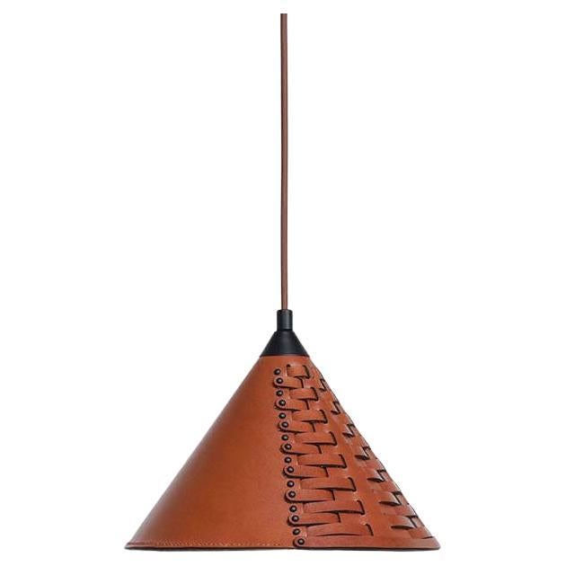 Koni Lamp is made of a single sheet of vegetable-tanned leather that is woven into a solid conical shape.
 
Traditionally, leather was woven for both decoration and reinforcement of the material. A flexible and soft material is made firm enough