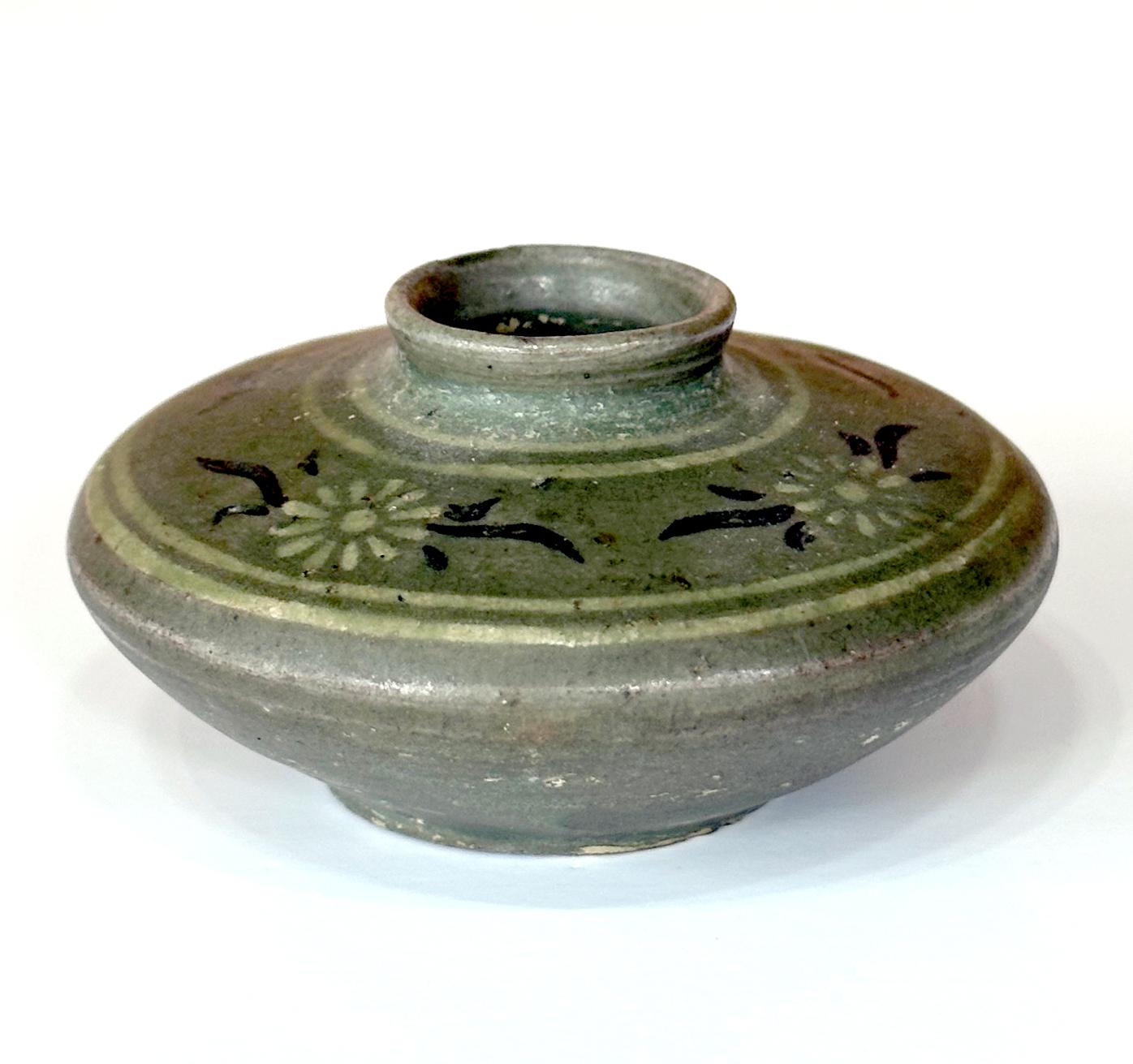 A small Korean ceramic celadon oil jar with inlay design from Goryeo Dynasty (918 to 1392AD) circa 12-13th century. This type of mini jars from Goryeo period, were made specifically to hold cosmetic oil in woman's quarter. The surface ornamentation