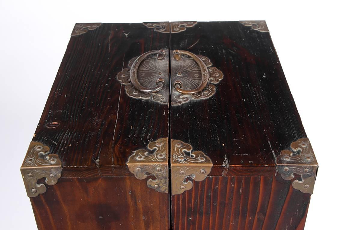 Lacquered exotic wood hinged two-part chest opening to multiple drawers on each side, all with incised character marks to identify the contents of each. Shaped lower frames with block feet and brass decorative incised hardware. The front decorative