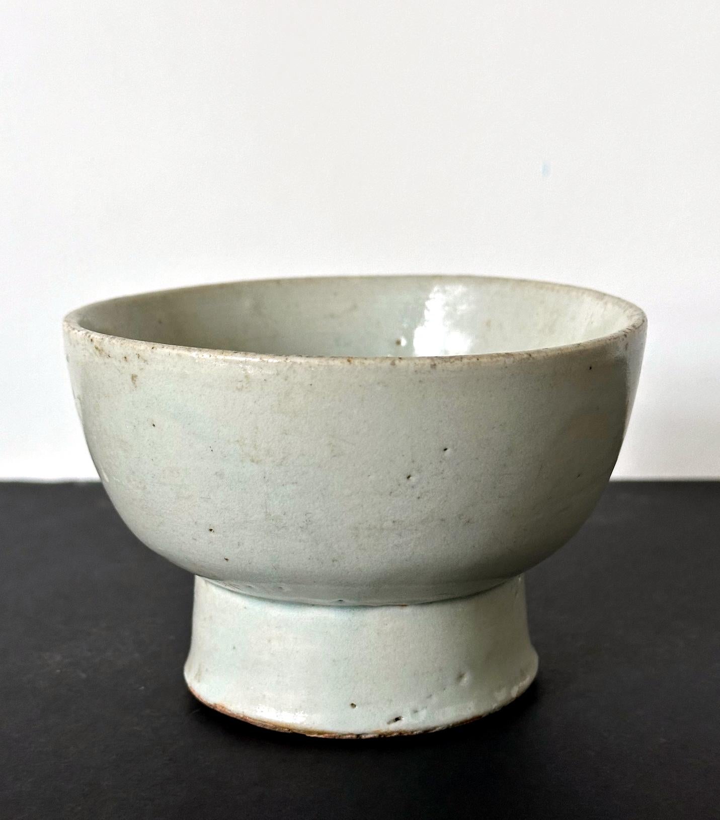 A ceramic stem bowl with high cylindrical pedestal foot in white glaze from Korea, circa 18 centuries of late Joseon Dynasty. By shape, this piece appears to be a ceremonial vessel that was used to make offerings on the altar. Although without