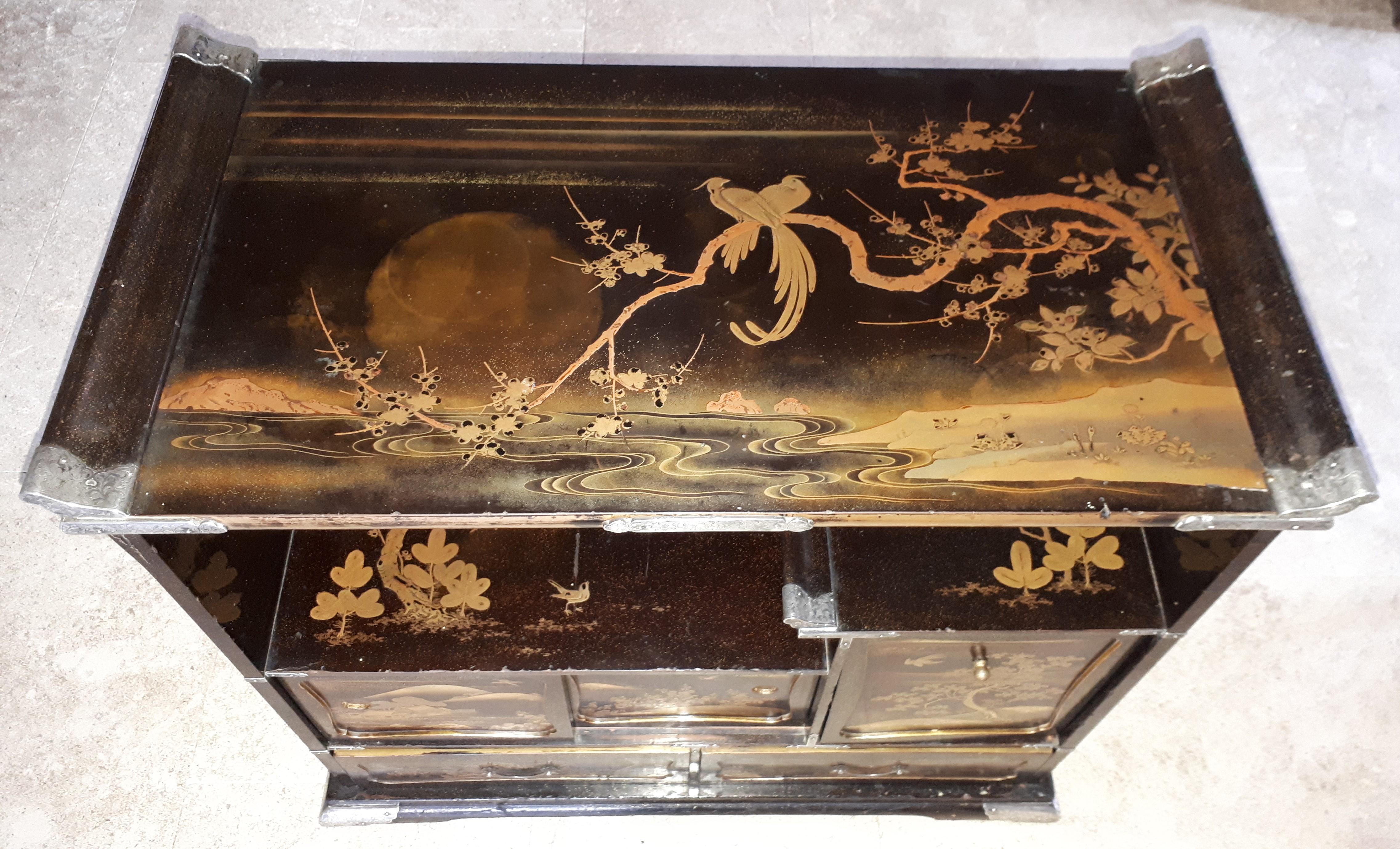 Precious and rare small kazaridana lacquered on all sides with two drawers and three panels decorated with fish, landscapes and birds. The removable panel reveals a locker with a small drawer. The different decorations in hira and taka-maki-e have