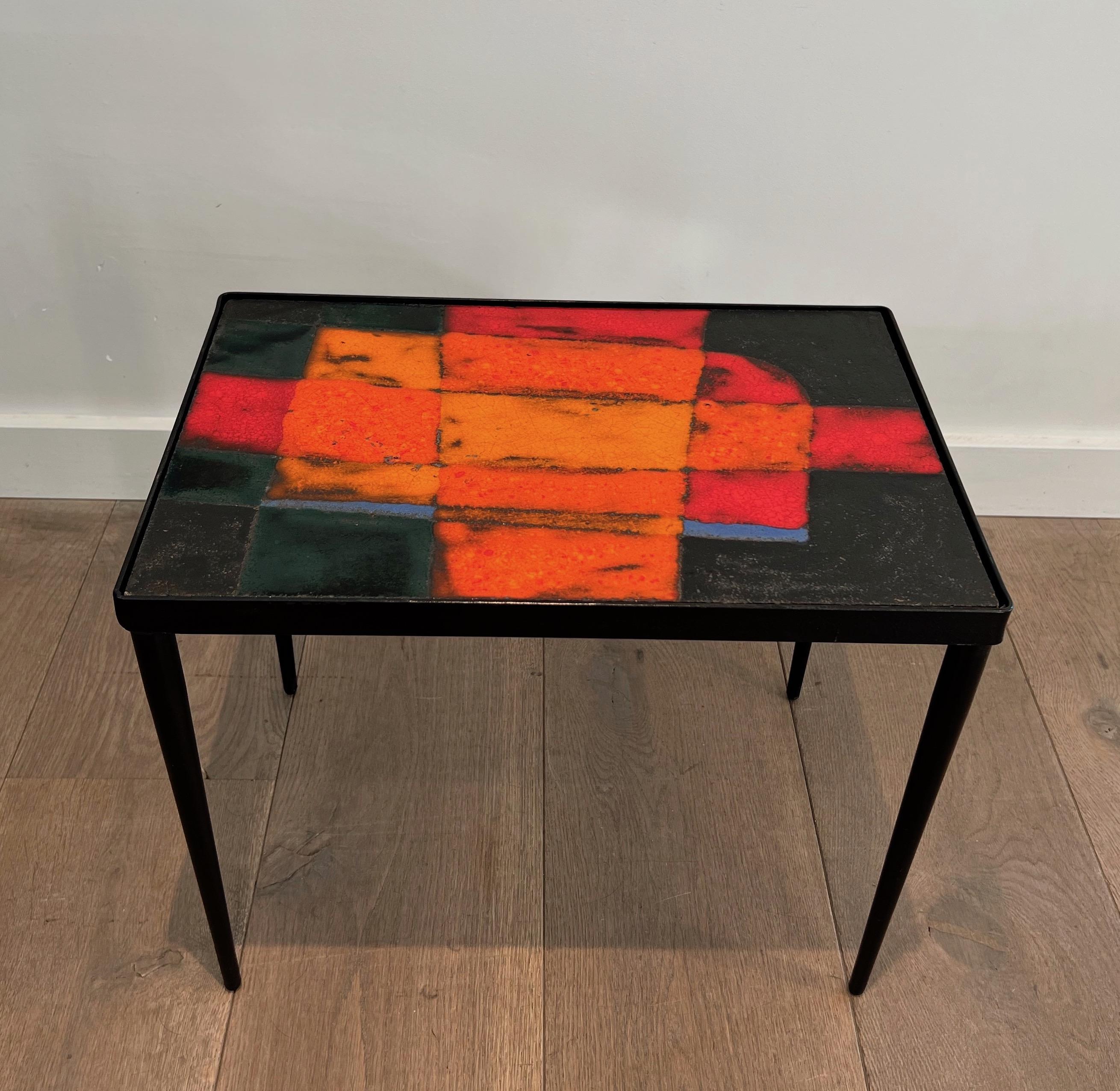 Very nice side table made of a balck lacquered metal base with a very nice colorfull ceramic top. This is a French work. Circa 1950