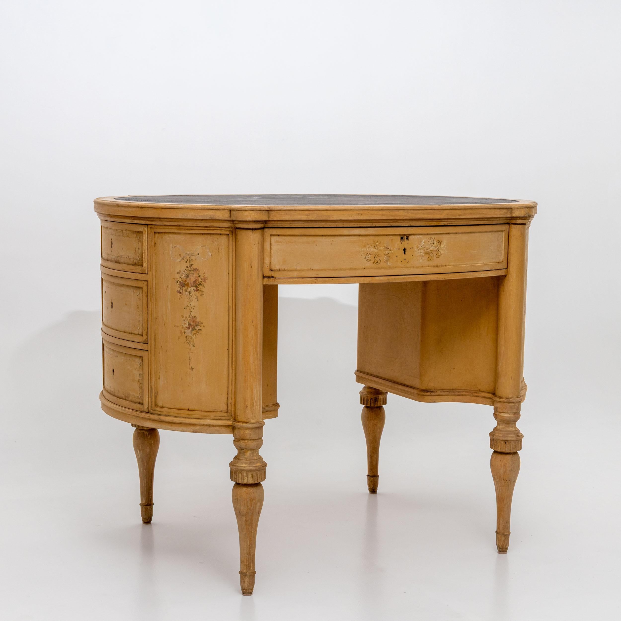 Small oval ladies' writing desk in Baroque style, featuring hand-painted floral decoration on a cream-colored base. Fitted with one wide central drawer and three narrow drawers in each of the rounded side sections. A decorative piece inspired by