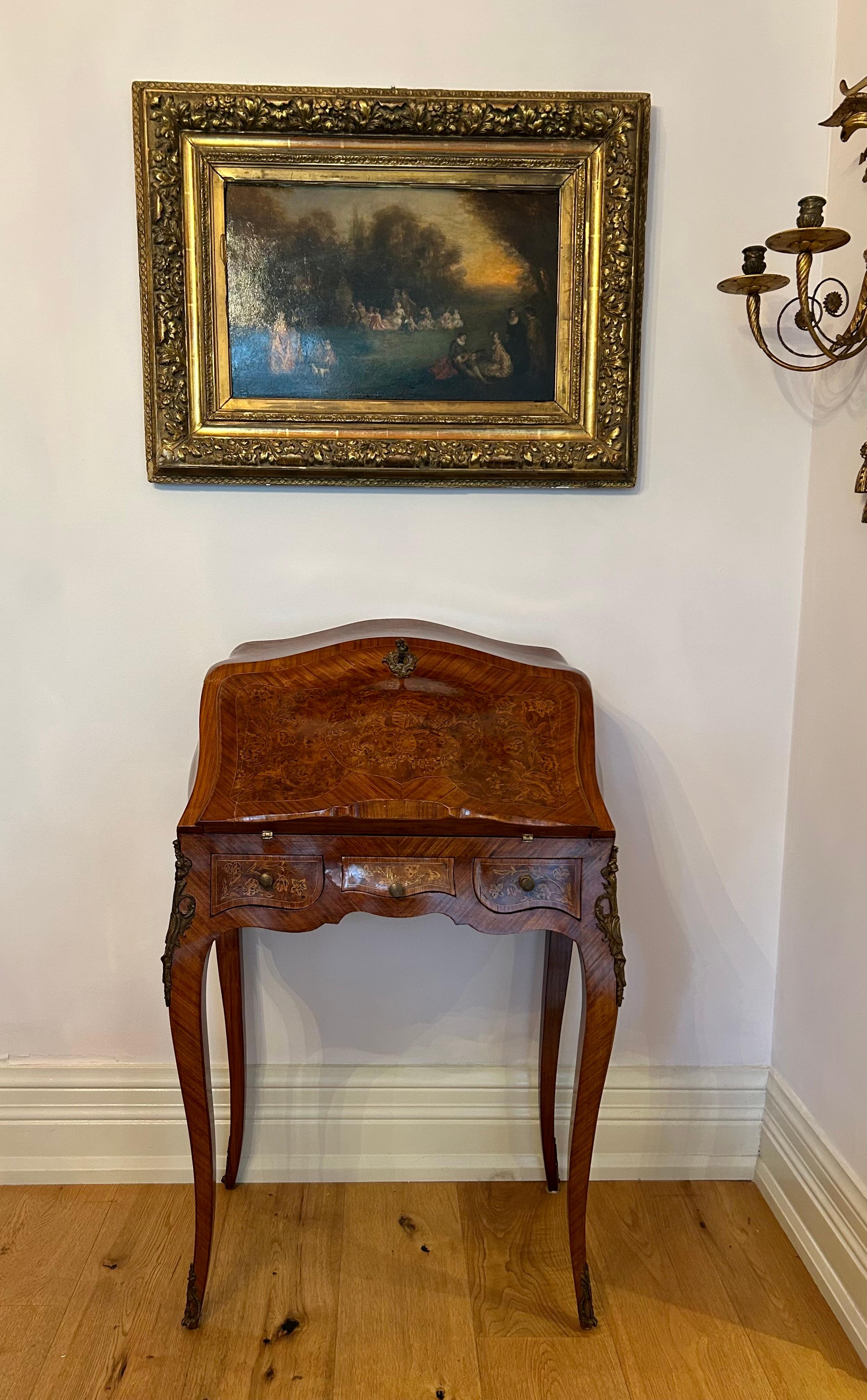 Il s'agit d'un glorieux petit bureau de dame français, aux détails de marqueterie exquis et aux formes ondulantes et bombées. La façade du bureau comporte trois petits tiroirs et un plateau fermé et incliné sur lequel des fleurs et des volutes