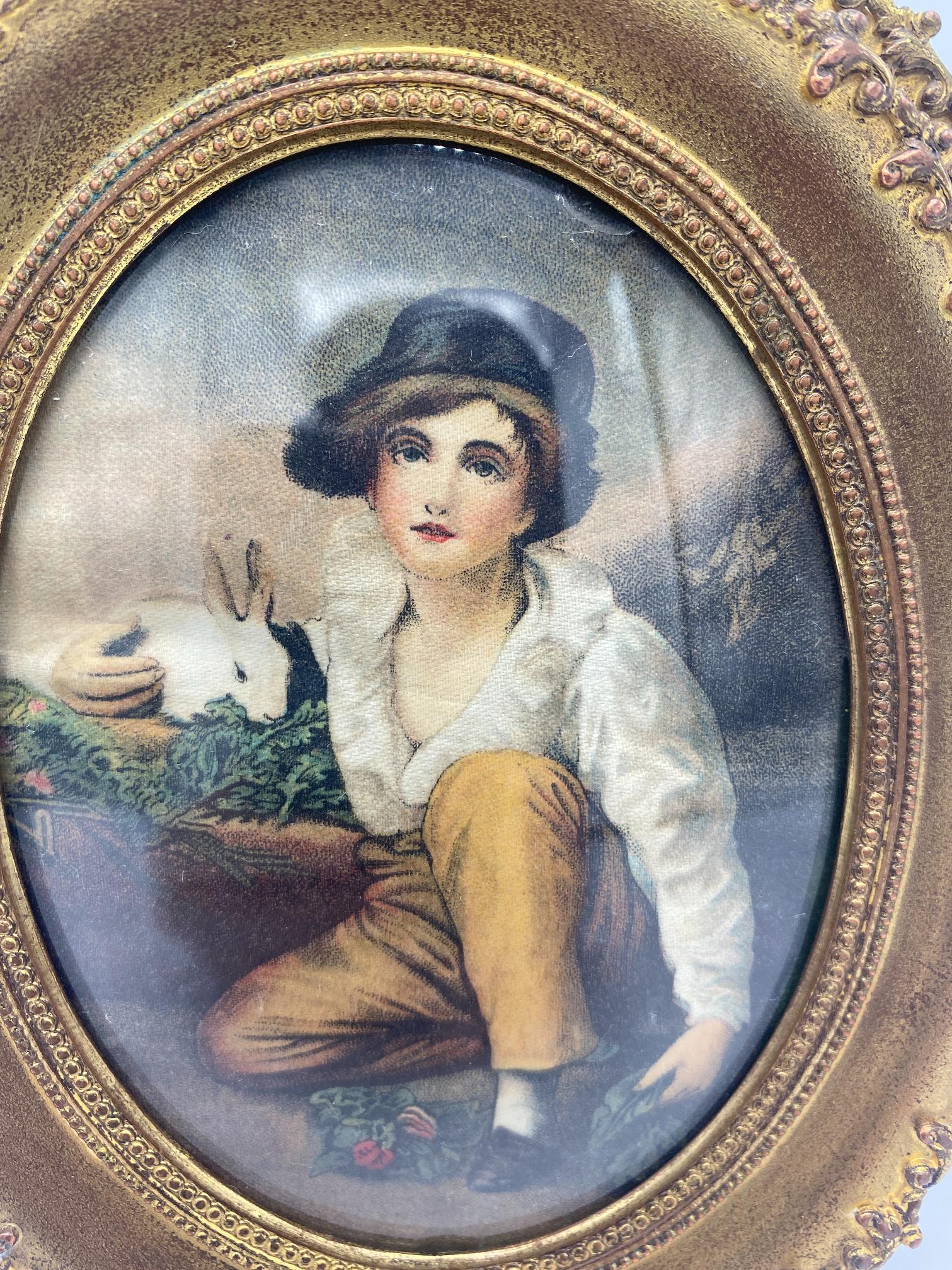 Small late 19th century silk painting depicting boy and rabbit in oval frame
Picture of a young boy with a rabbit and leafy vegetables painted on silk. Bowed glass has chip on edge. Gilt brass easel frame. Measures: 7
