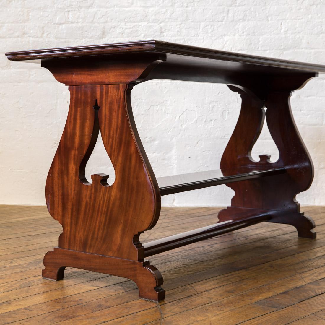 A top quality solid mahogany table that probably originated as a library table although it would equally be at home as a dining table. Very solid, with it's undershelf and lower stretcher. The end supports have a Arts & Crafts feel, with the simple