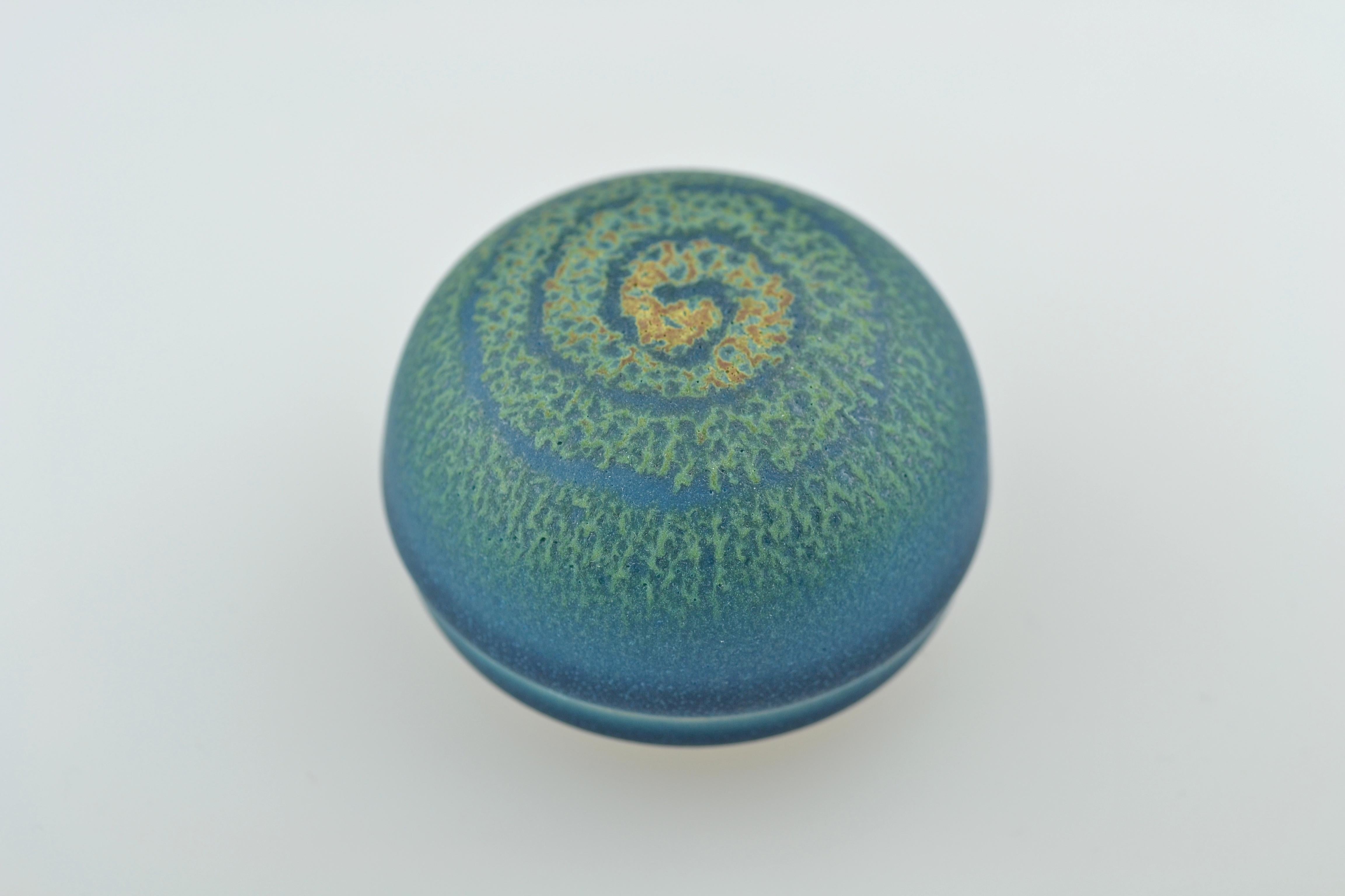 The small ceramic case with a dome-shaped lid resting on a small circular stand is for storing incense (kôgô). Beautiful kôgô are used for representational purposes within the tea ceremony, after the incense is placed in the charcoal brazier during