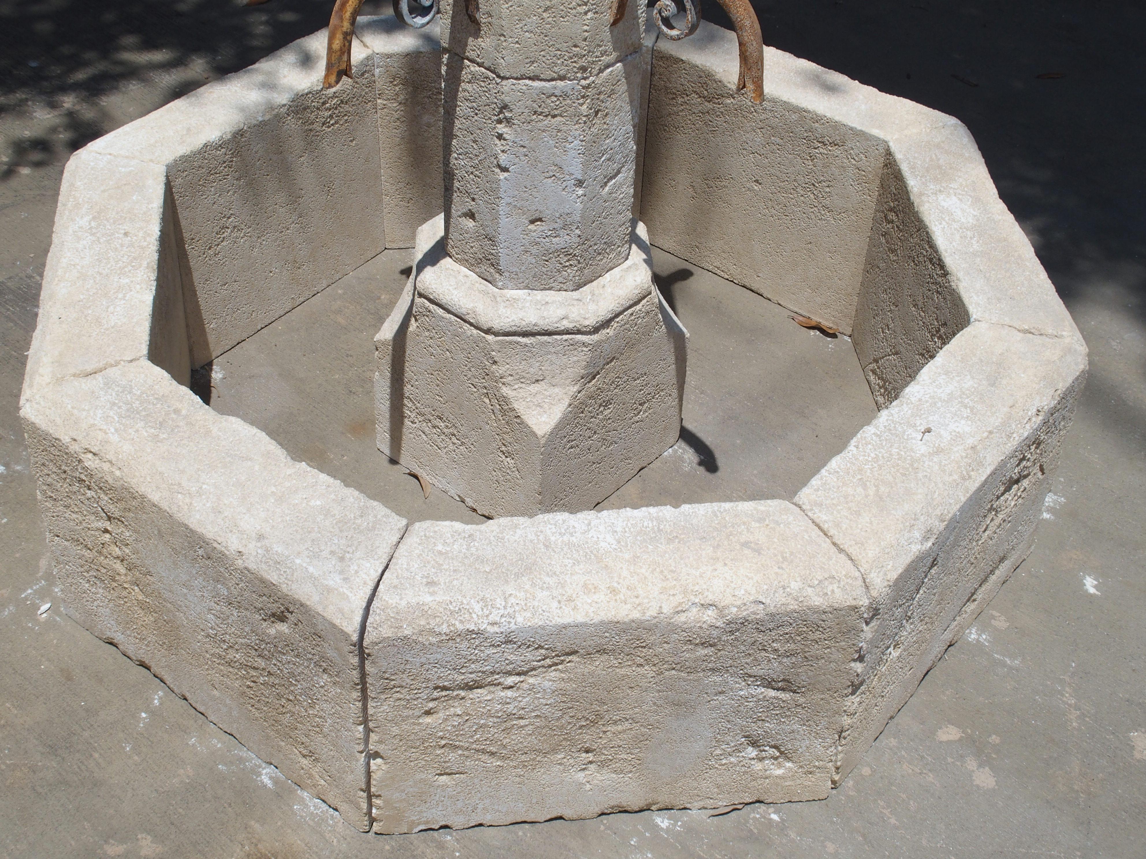 This wonderfully hand carved limestone, small centre fountain from France is octagonal in shape. It has four iron spouts that adorn the centre post. Always used as center fountains in villages throughout the ages in France, they are a beautiful