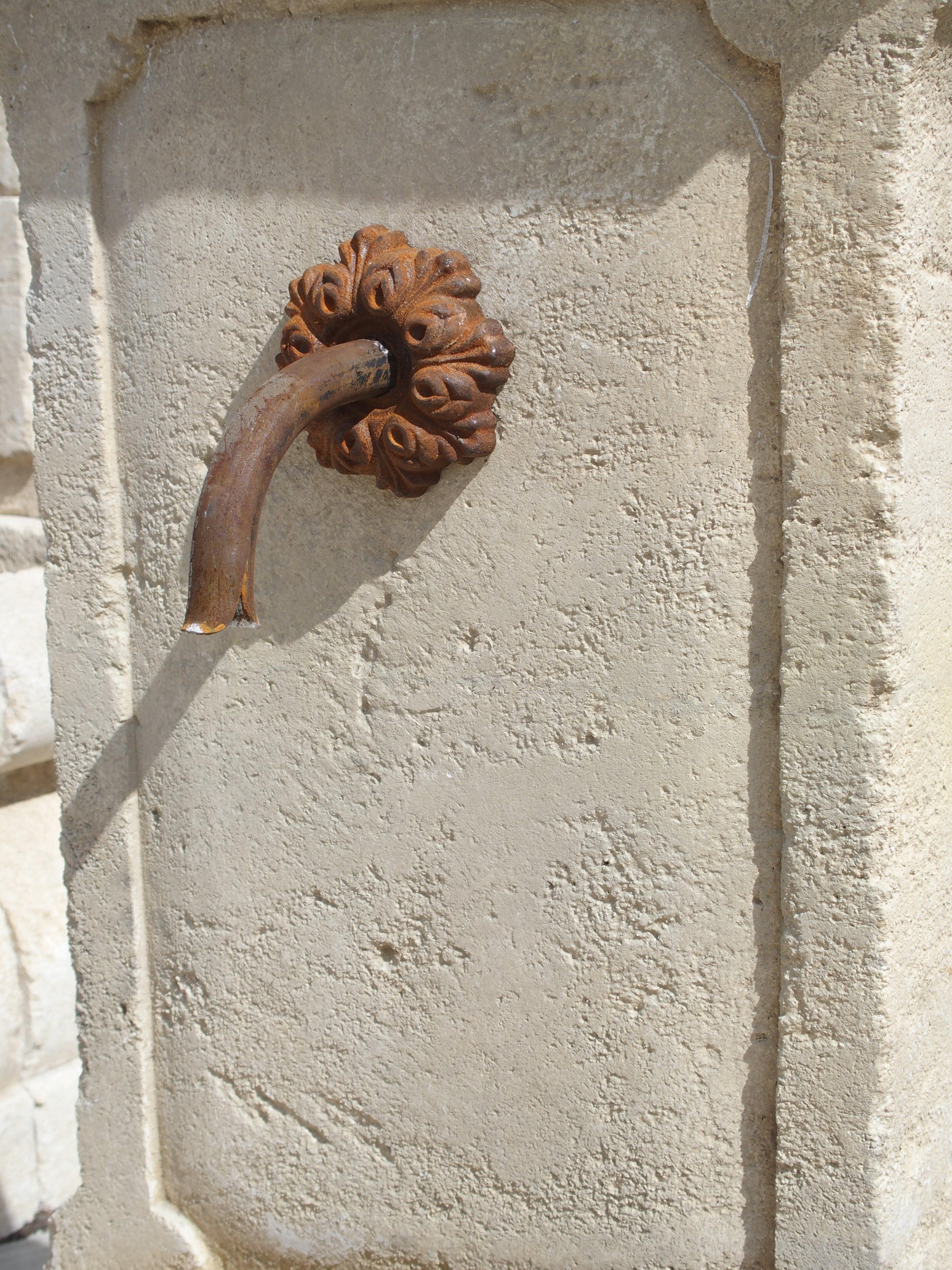 This small wall fountain has been hand carved in Provence, France. It has an in-carved paneled back with shaped indents which is repeated on the front of the basin portion. The outside shape of the back also mirrors the design of the in- carving.