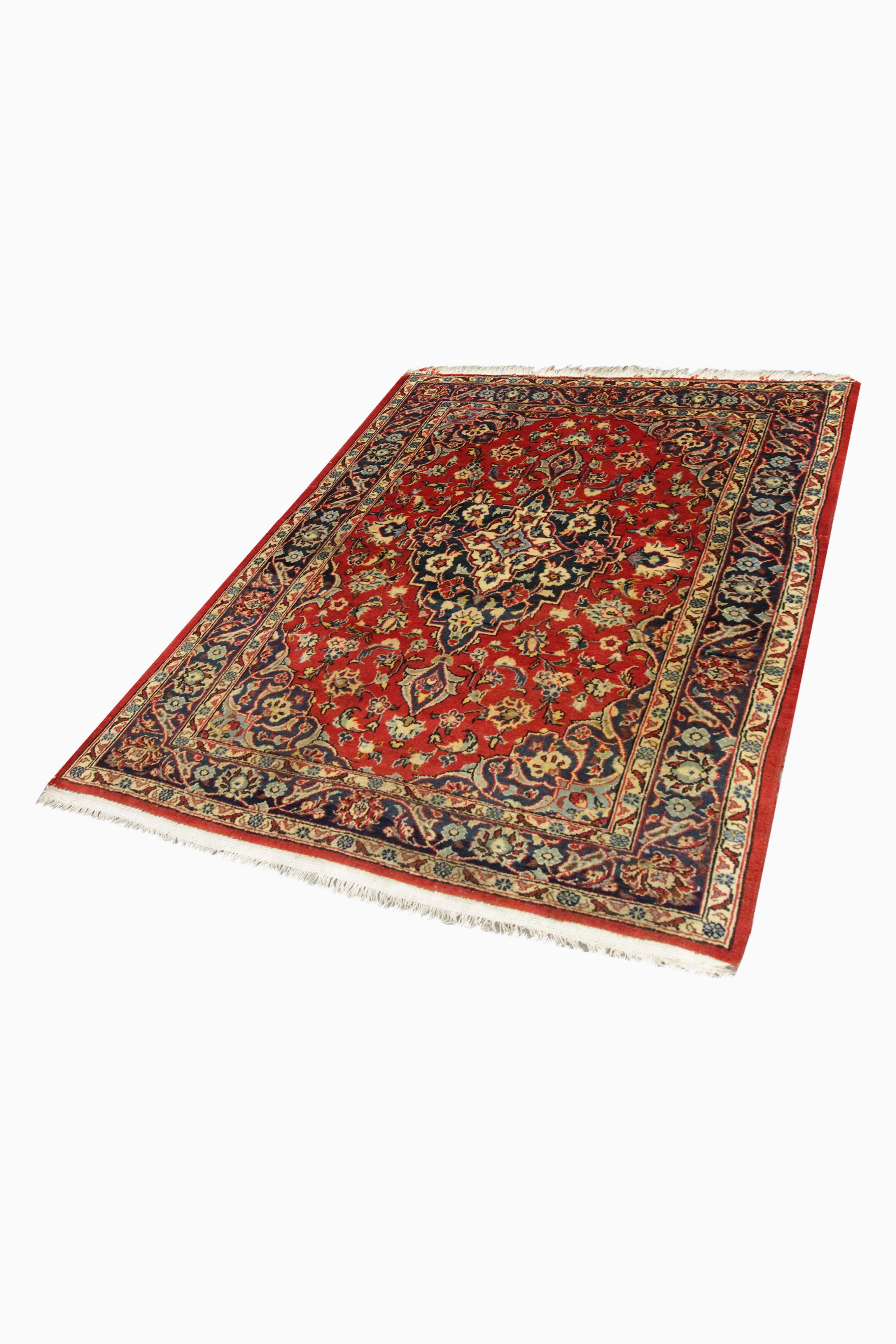 This fine handwoven oriental wool area rug is a fantastic example of vintage rugs woven in the mid 20th century. The design has been woven on a rich red background with accents of blue, beige, rust and green accents that make up the intricate